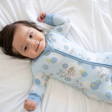 Baby in a blue Neopets blueberry print zip pajama.