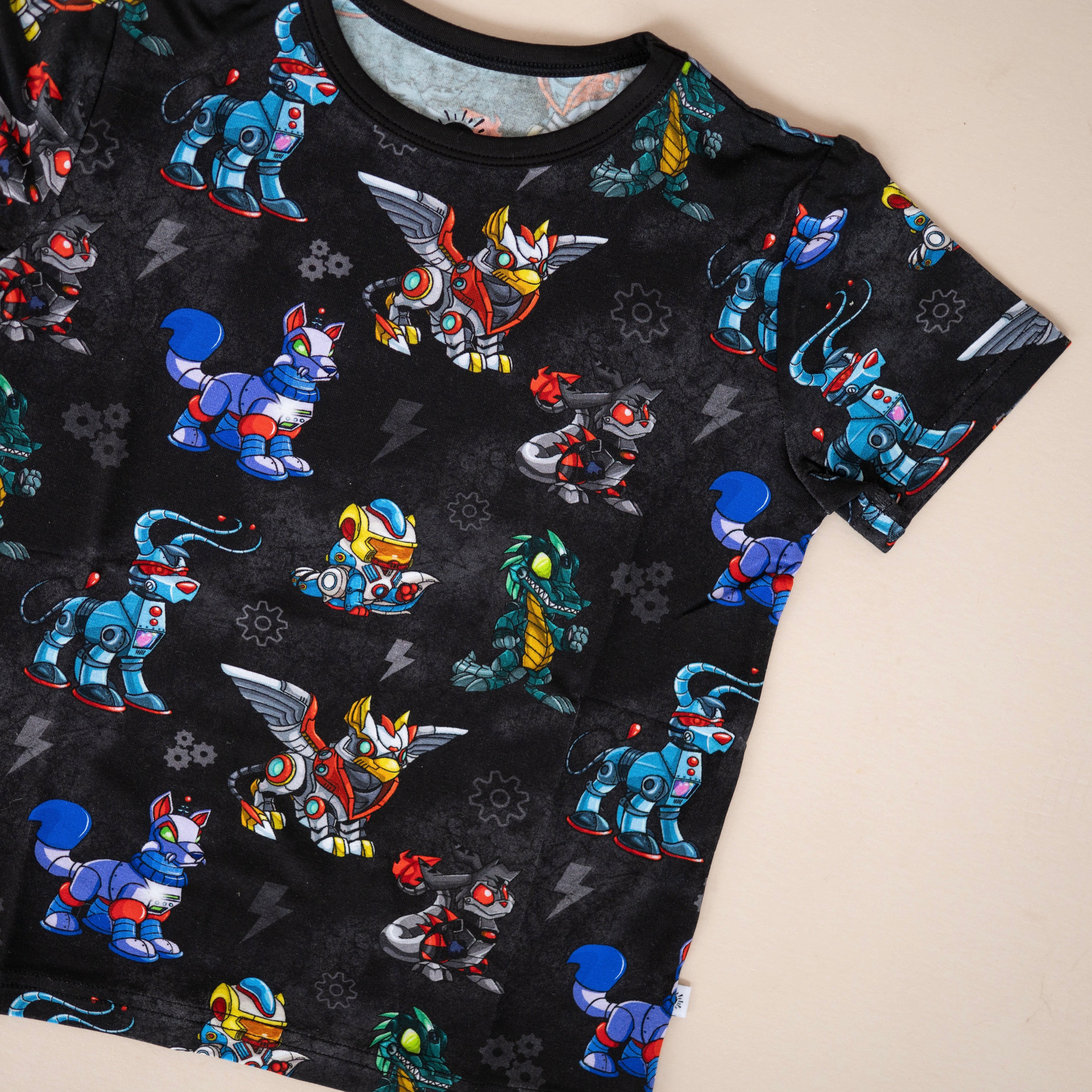 T-shirt with a black background featuring a repeating pattern of colorful robot animals.