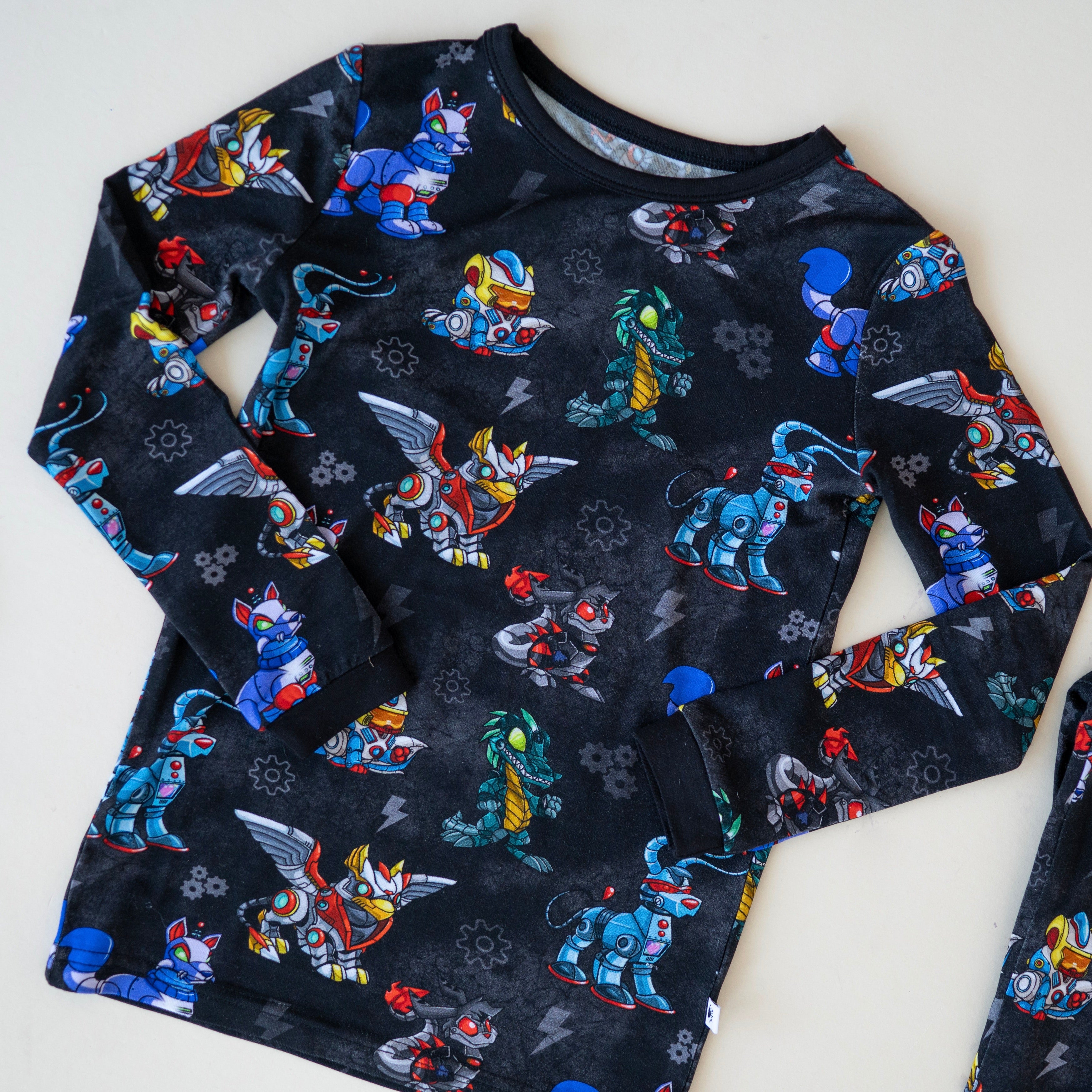 A black long-sleeved shirt with a pattern of colorful robot animals.
