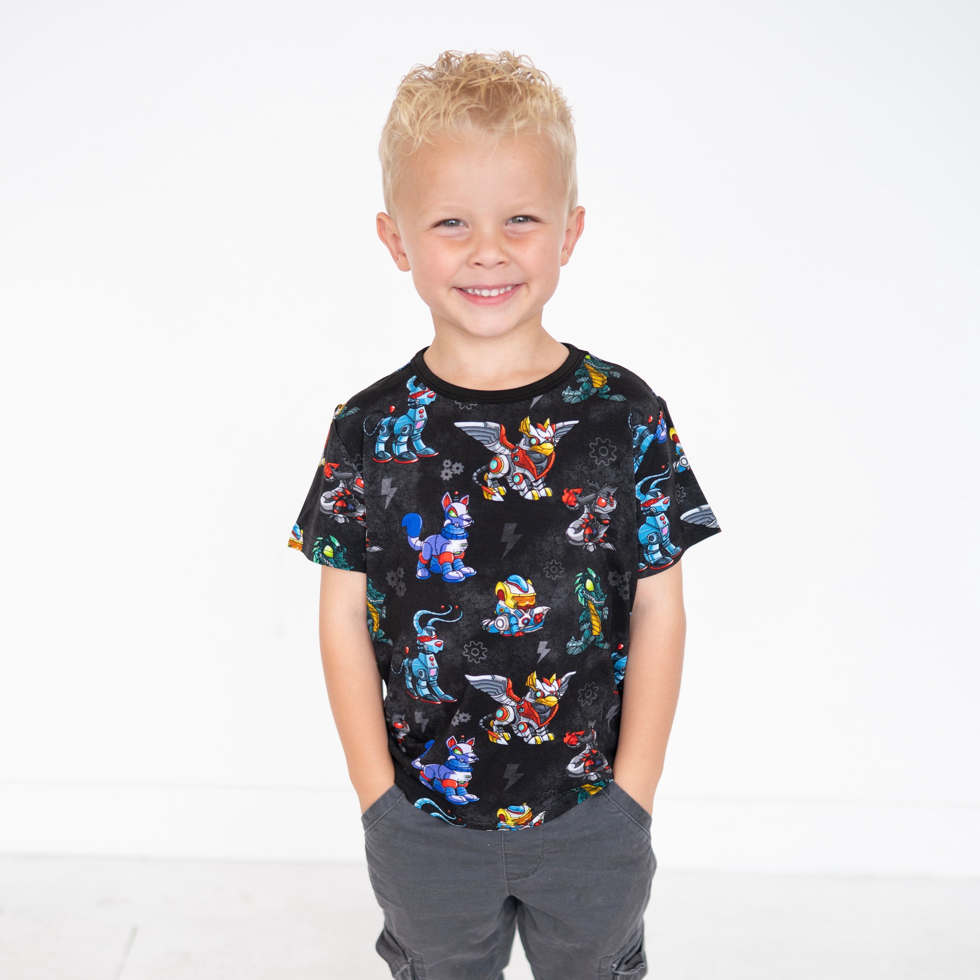 A young boy wears a black t-shirt with a robot Neopets pattern.