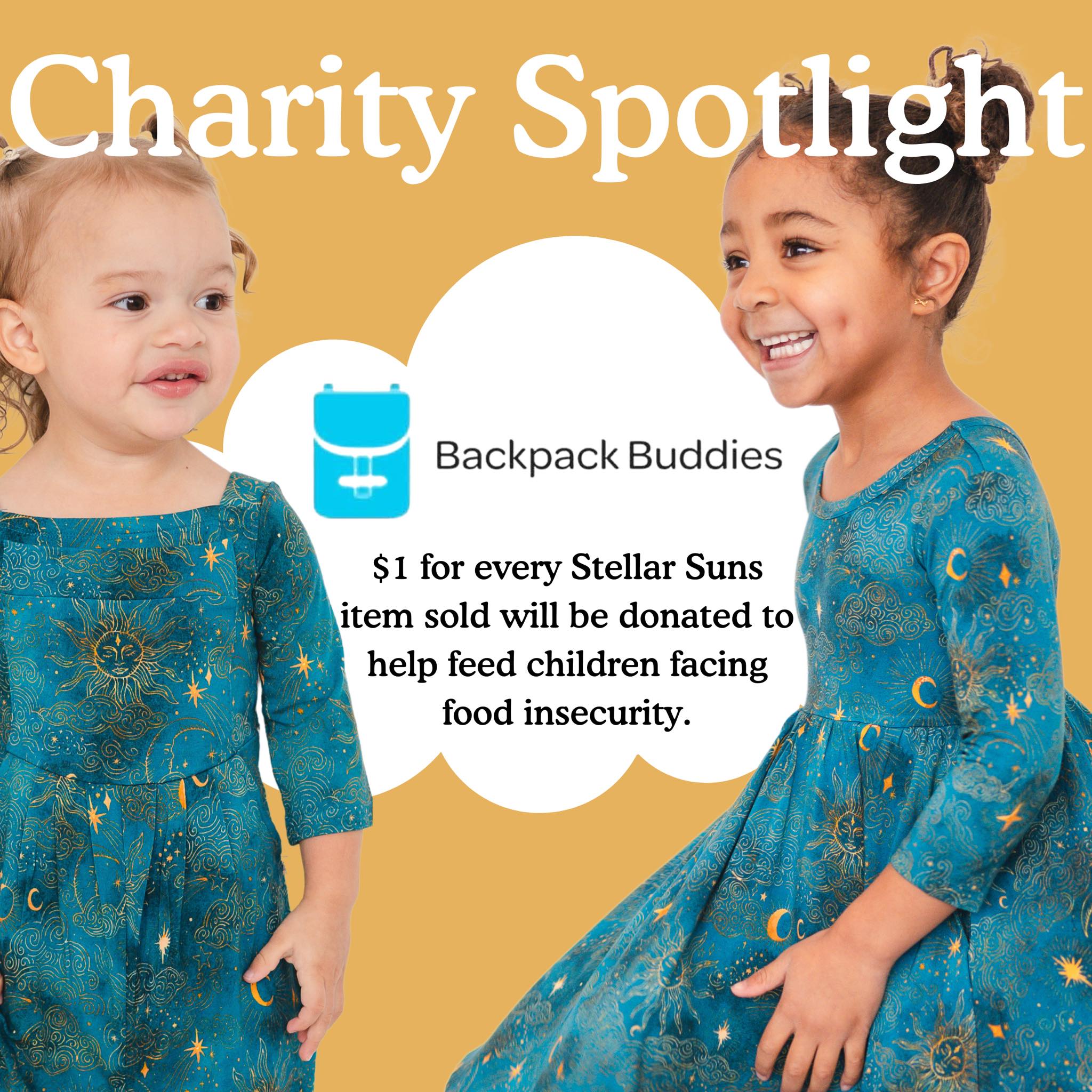 Two young girls in teal dresses with sun and moon patterns.