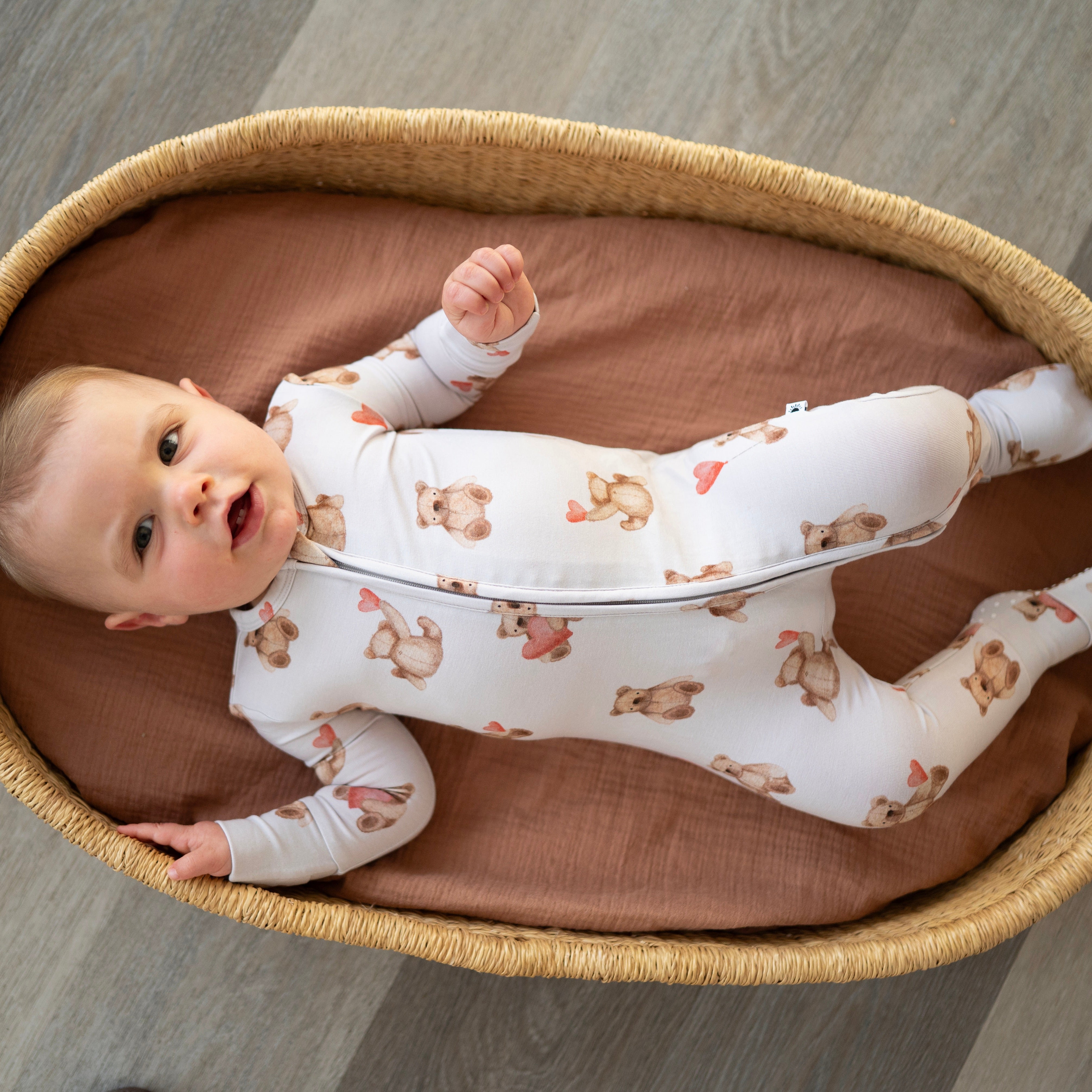 Baby in a white pajama set with teddy bear print.