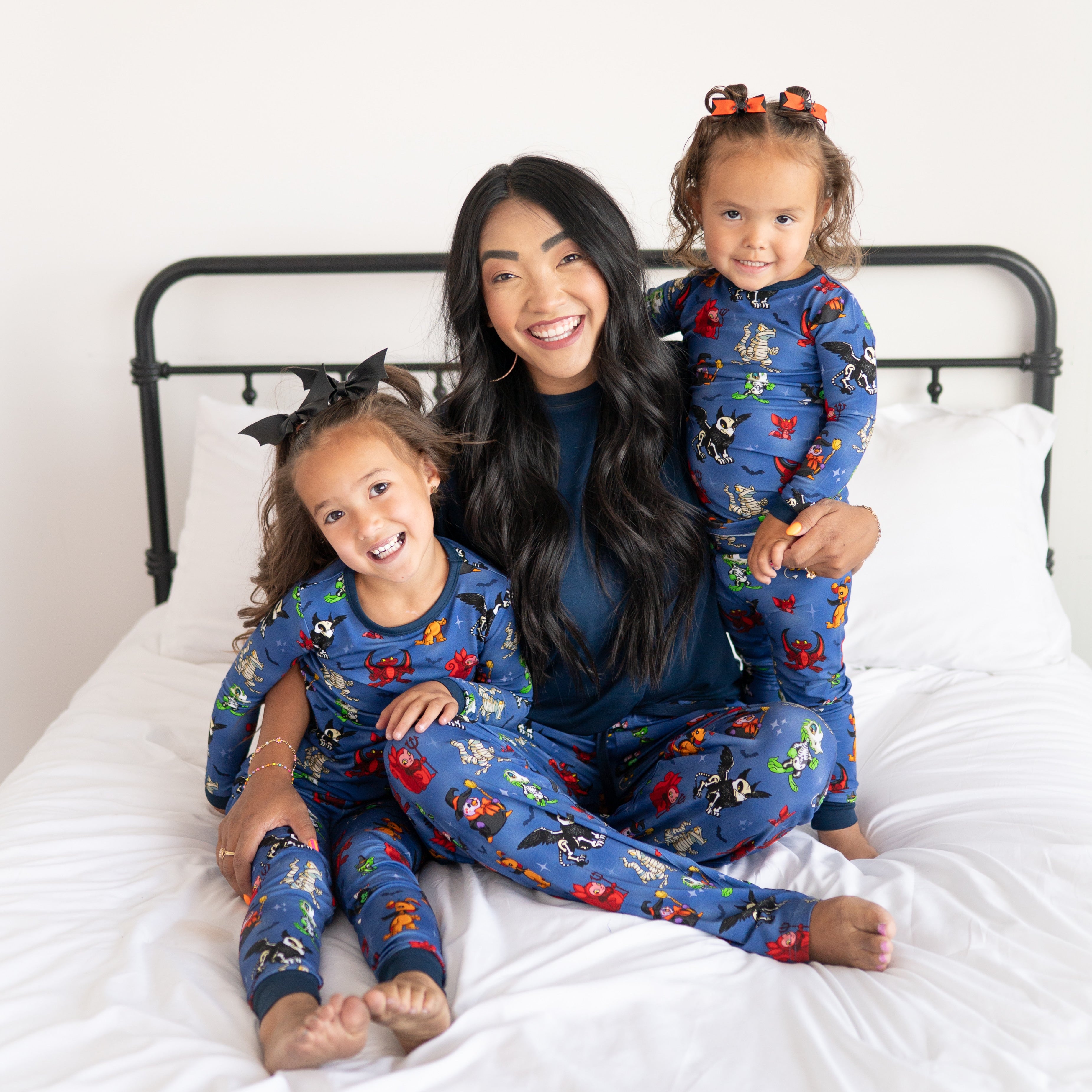A mother and two daughters in matching Halloween-themed Neopets pajamas.