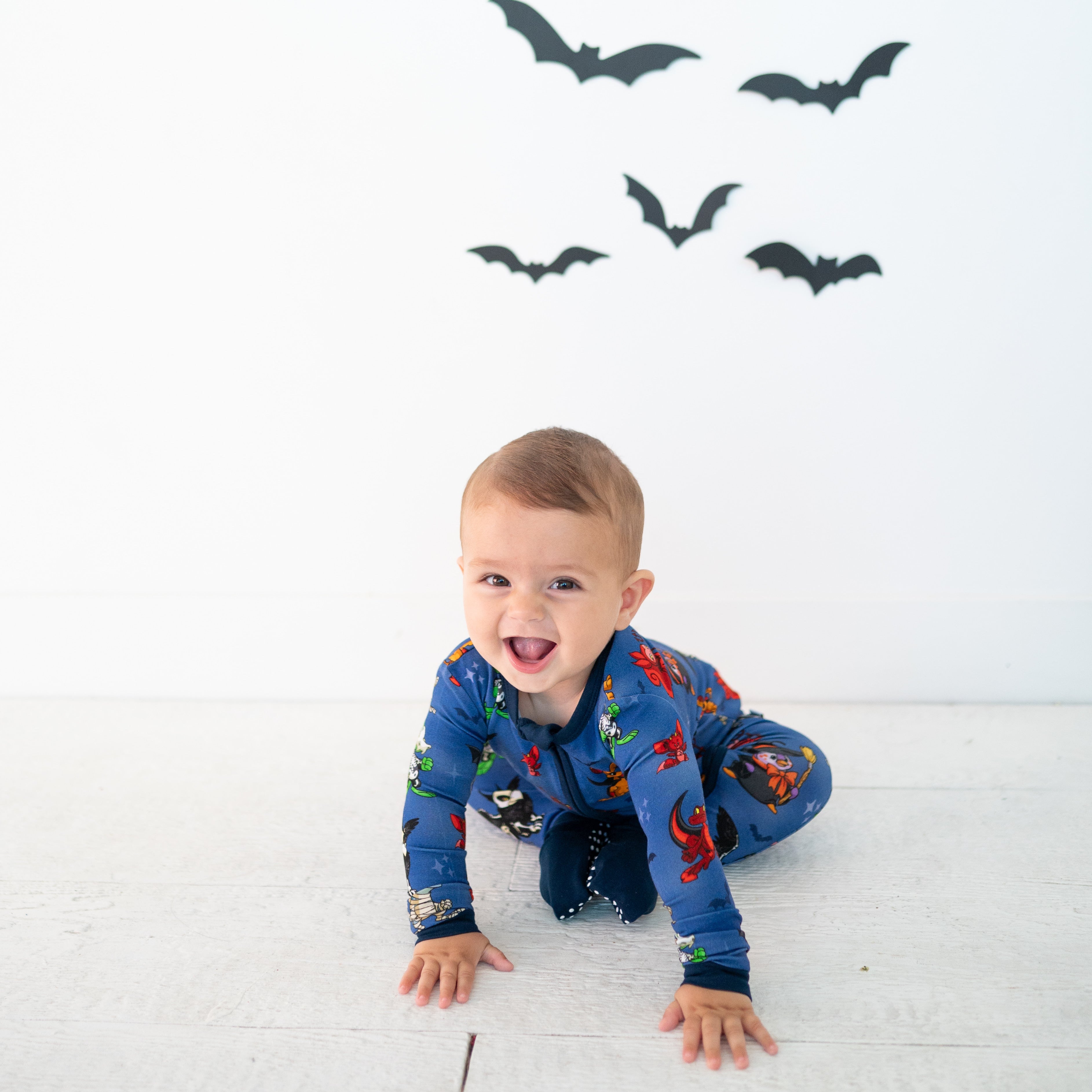 Baby in blue Halloween pajamas with Neopets characters.
