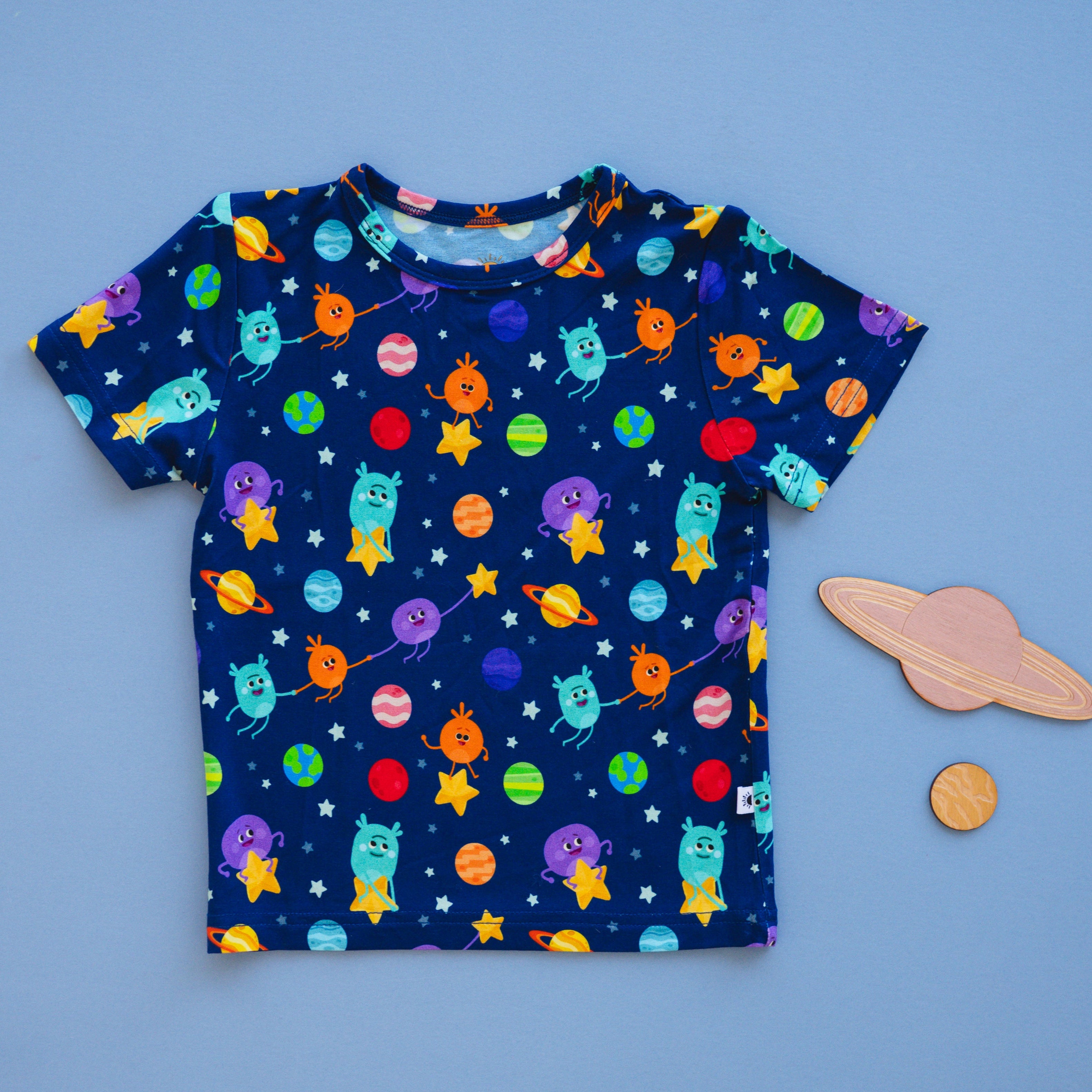 A dark blue t-shirt with a space-themed print of planets and cartoon aliens.