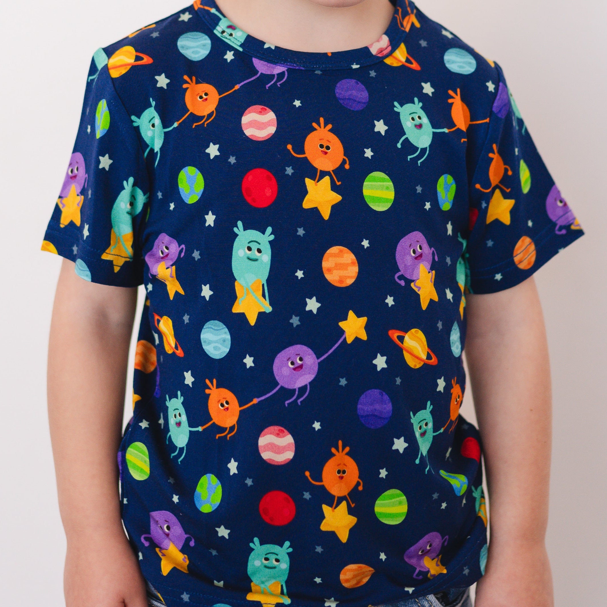 A navy t-shirt with a colorful space-themed print of cartoon aliens and planets.