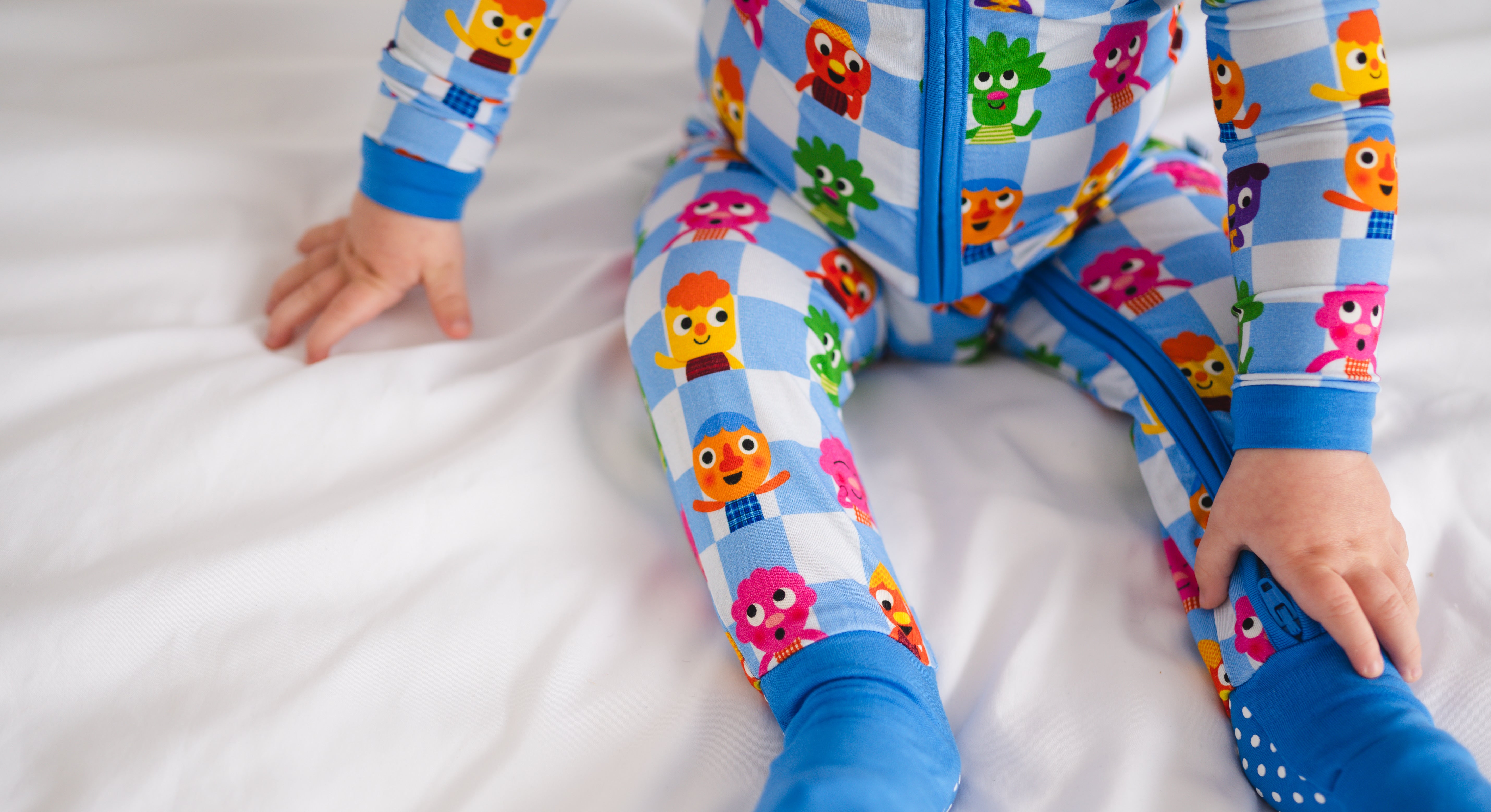 A child wears blue and white checkered pajamas with colorful cartoon characters.