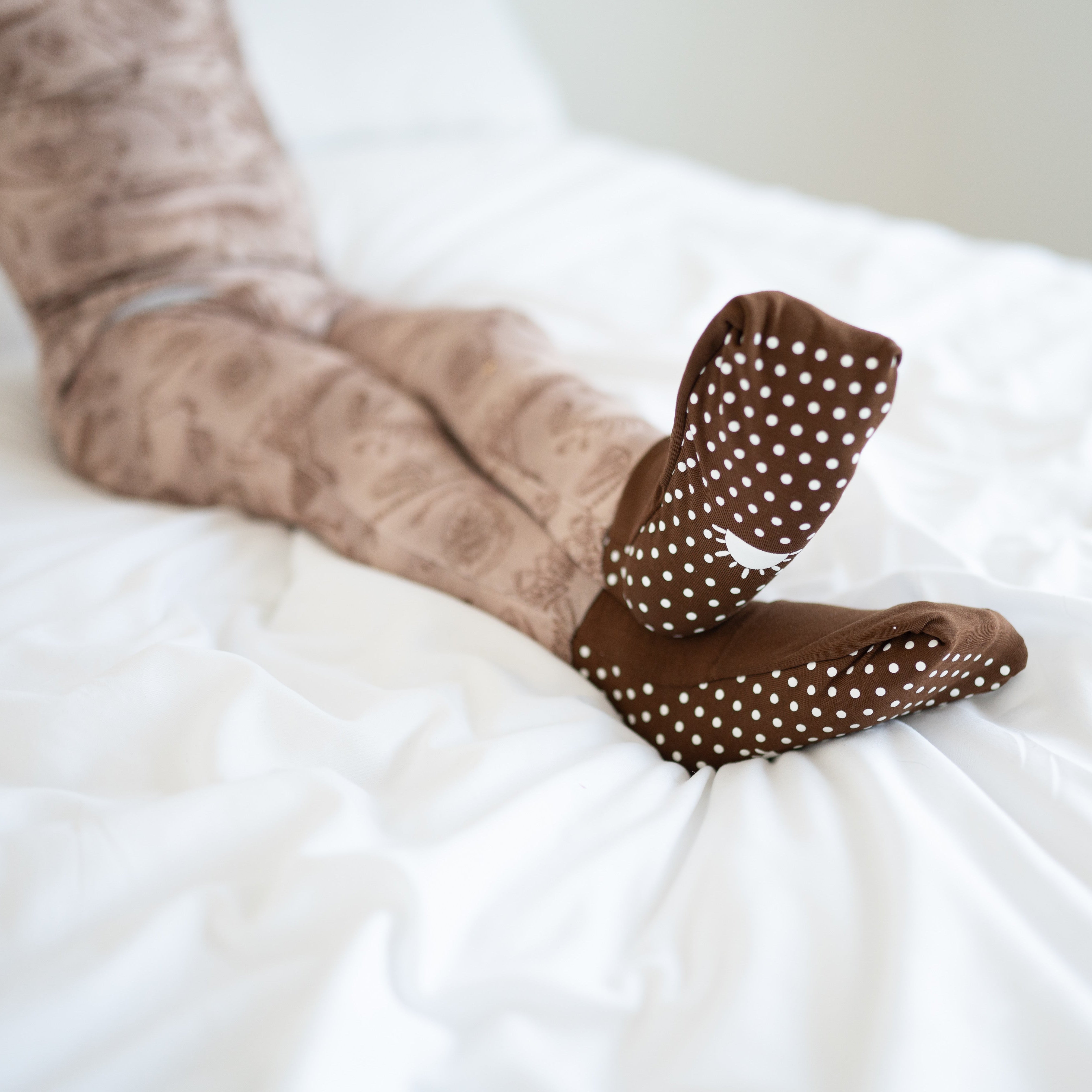 Brown bamboo pajamas with white polka dot foot grips.