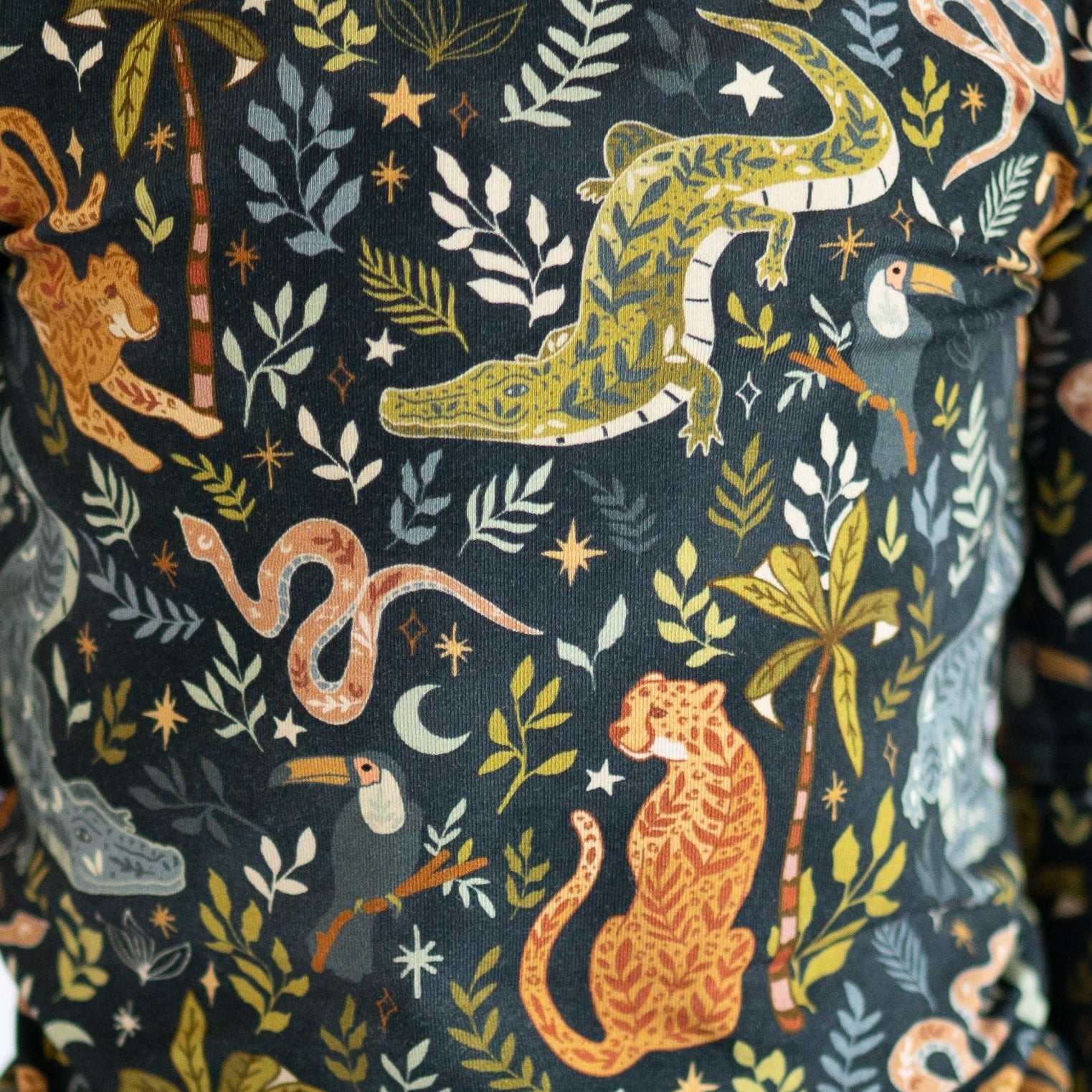 A dark blue pajama set with a jungle print featuring animals and plants.