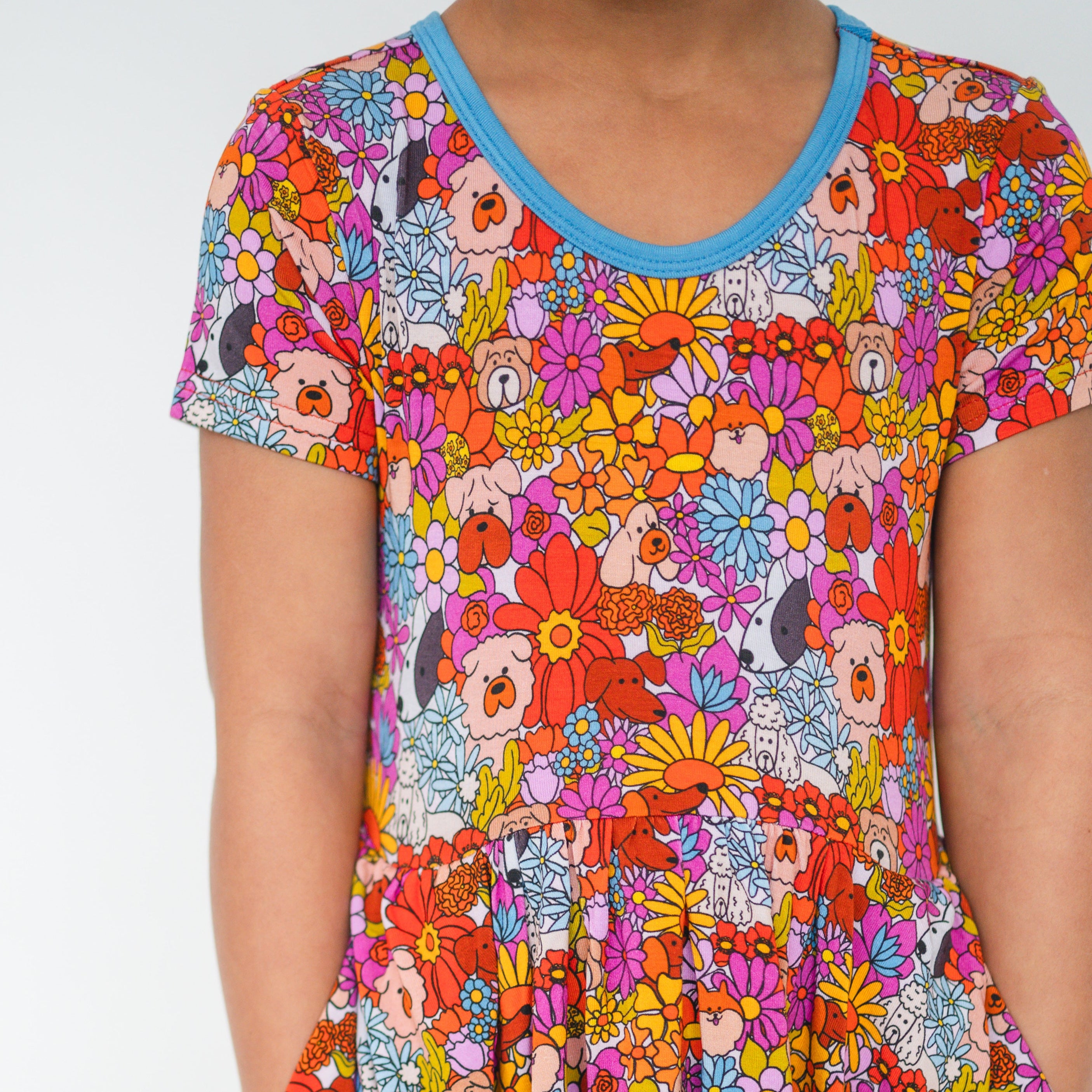 A child's dress with a colorful floral and dog print.