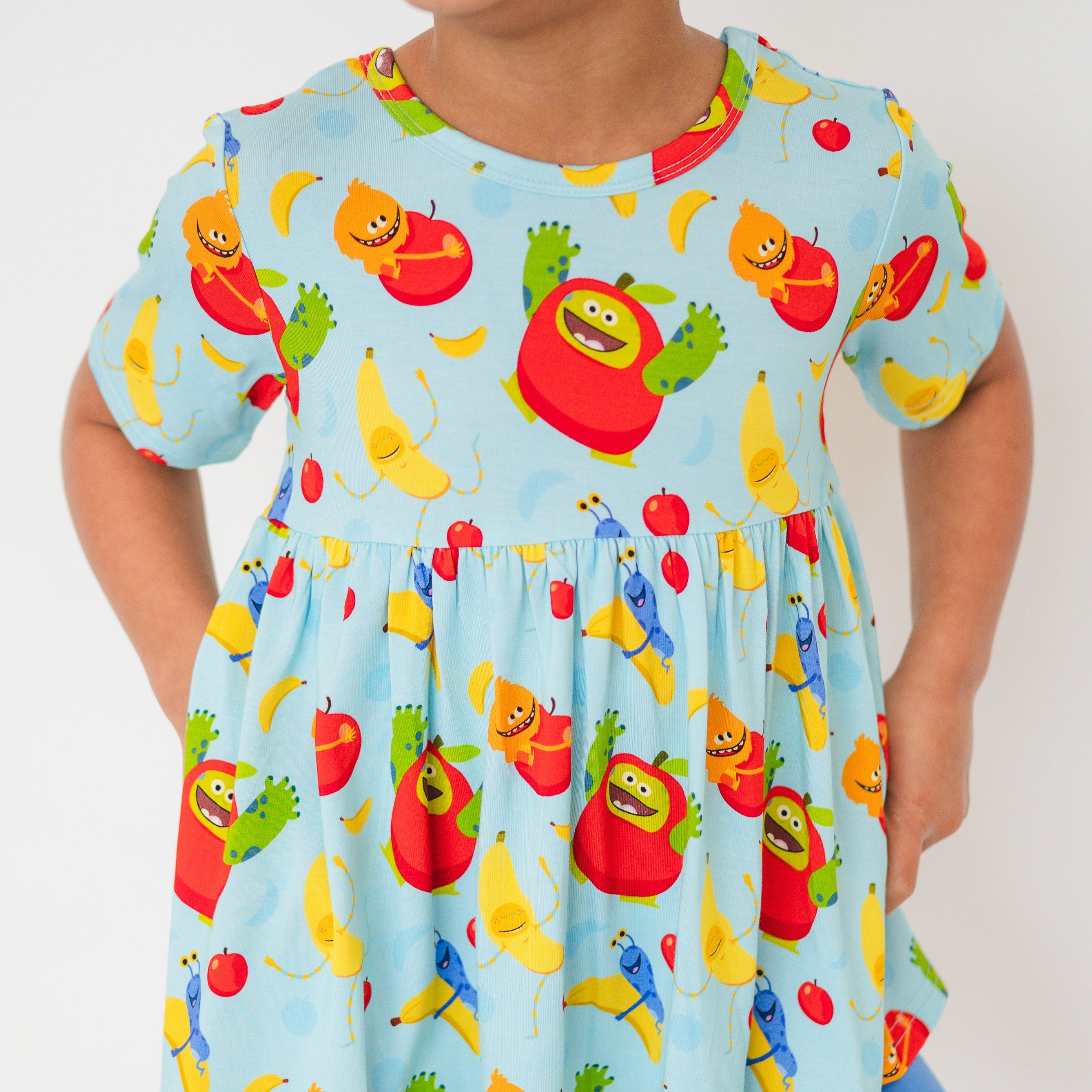Light blue peplum top with apples and bananas print.
