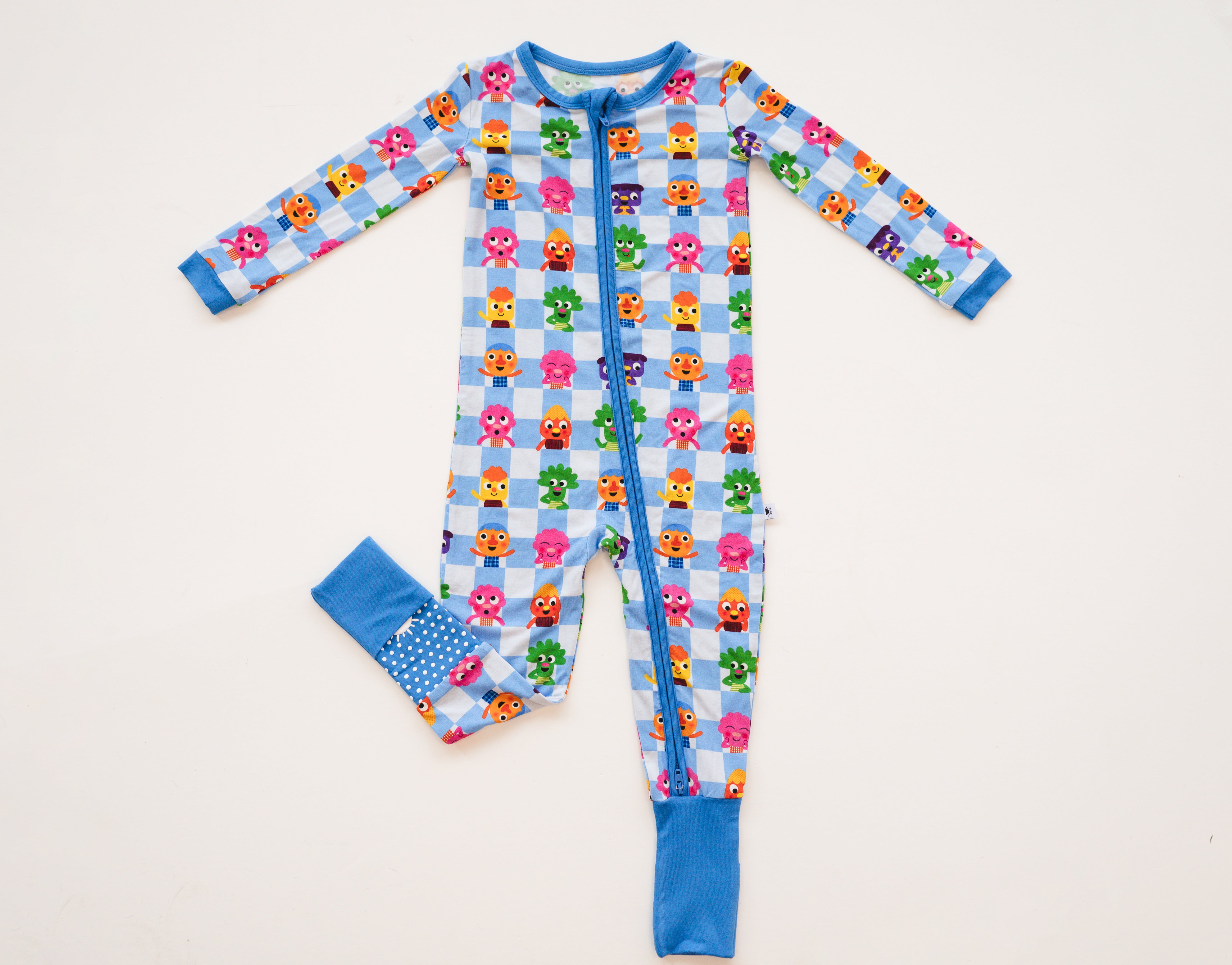 A blue and white checkered pajama set with colorful cartoon characters and a blue polka dot cuff.