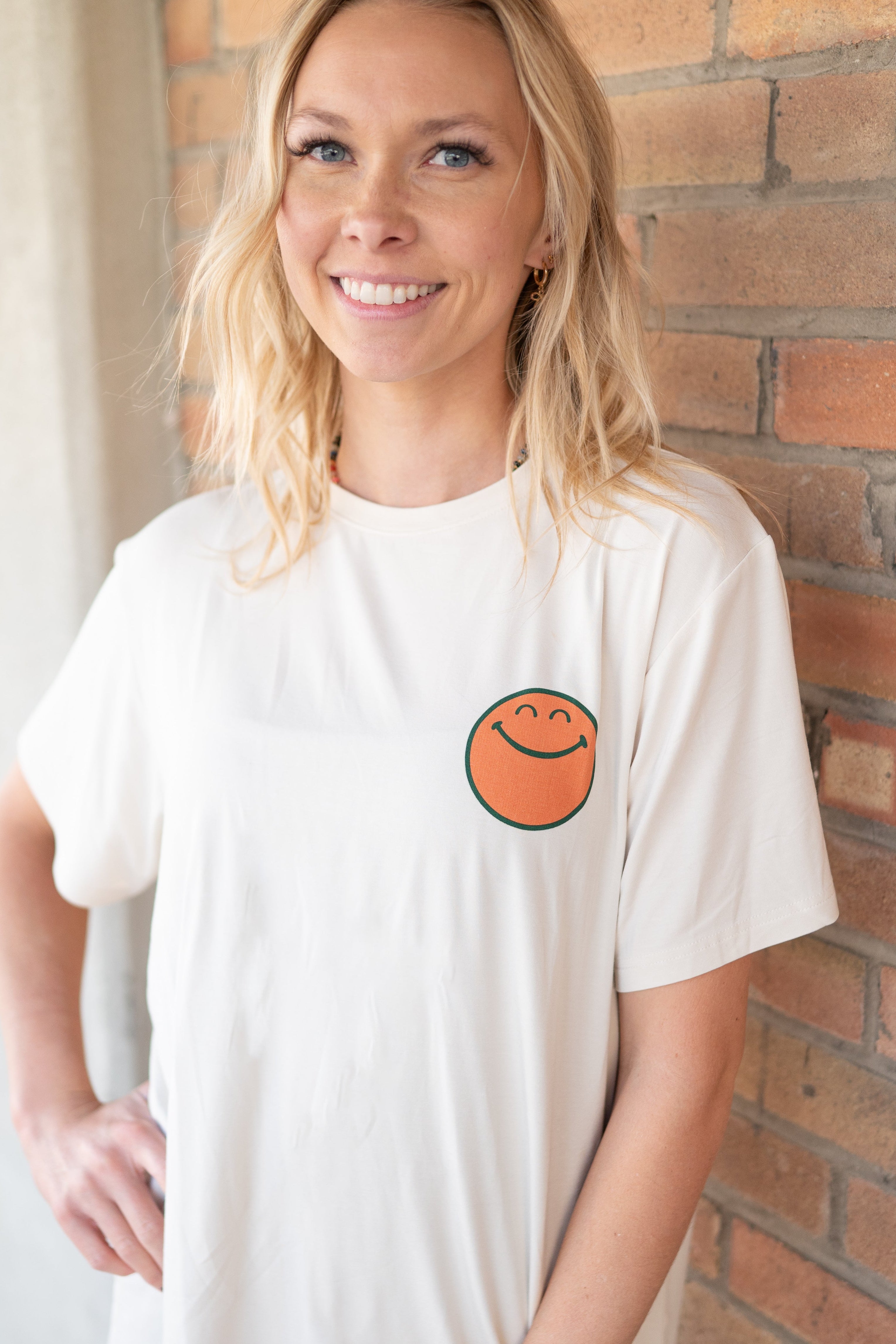 Cream oversized t-shirt with a smiley face graphic.