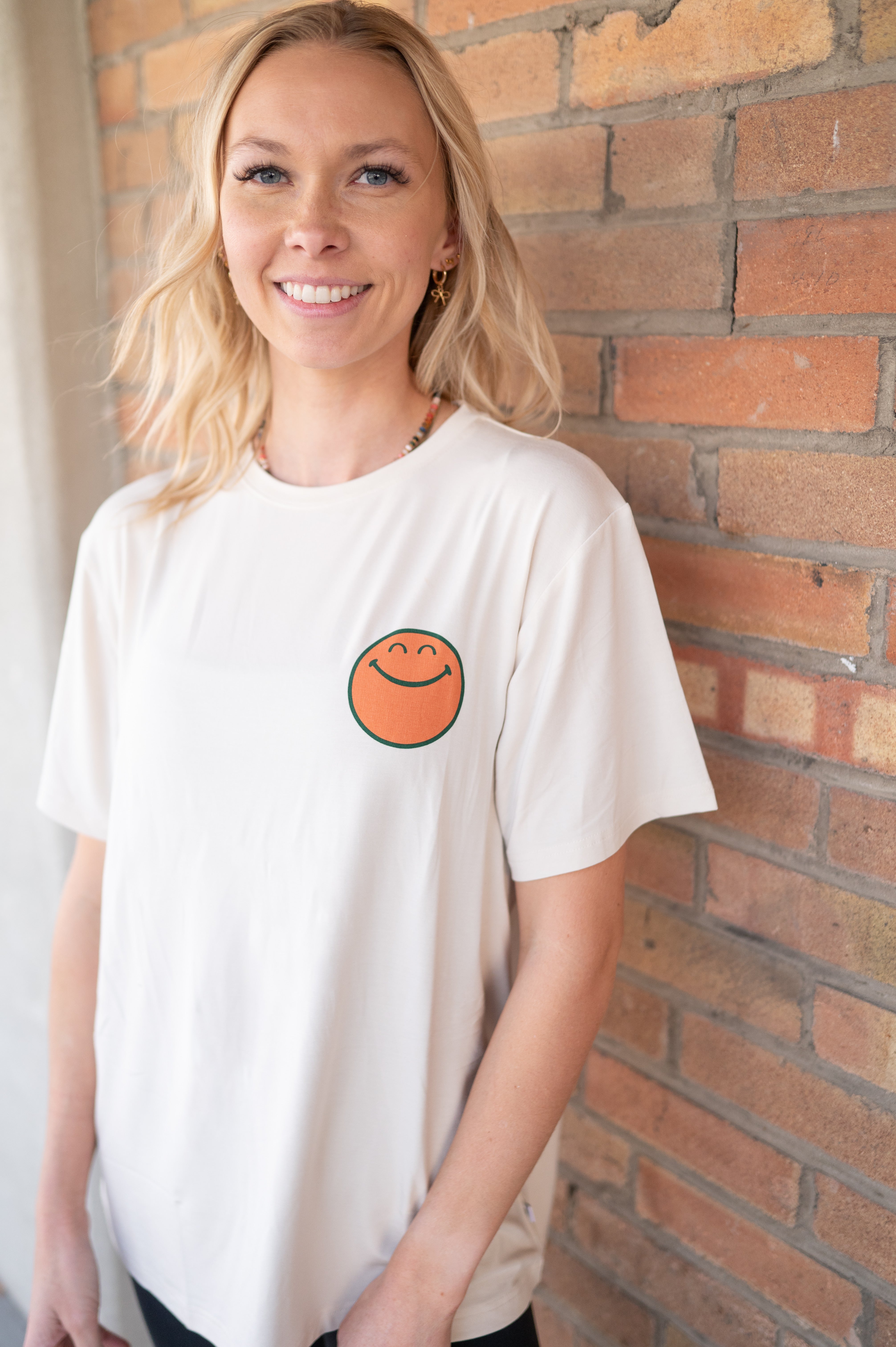 Cream oversized t-shirt with a smiley face graphic.