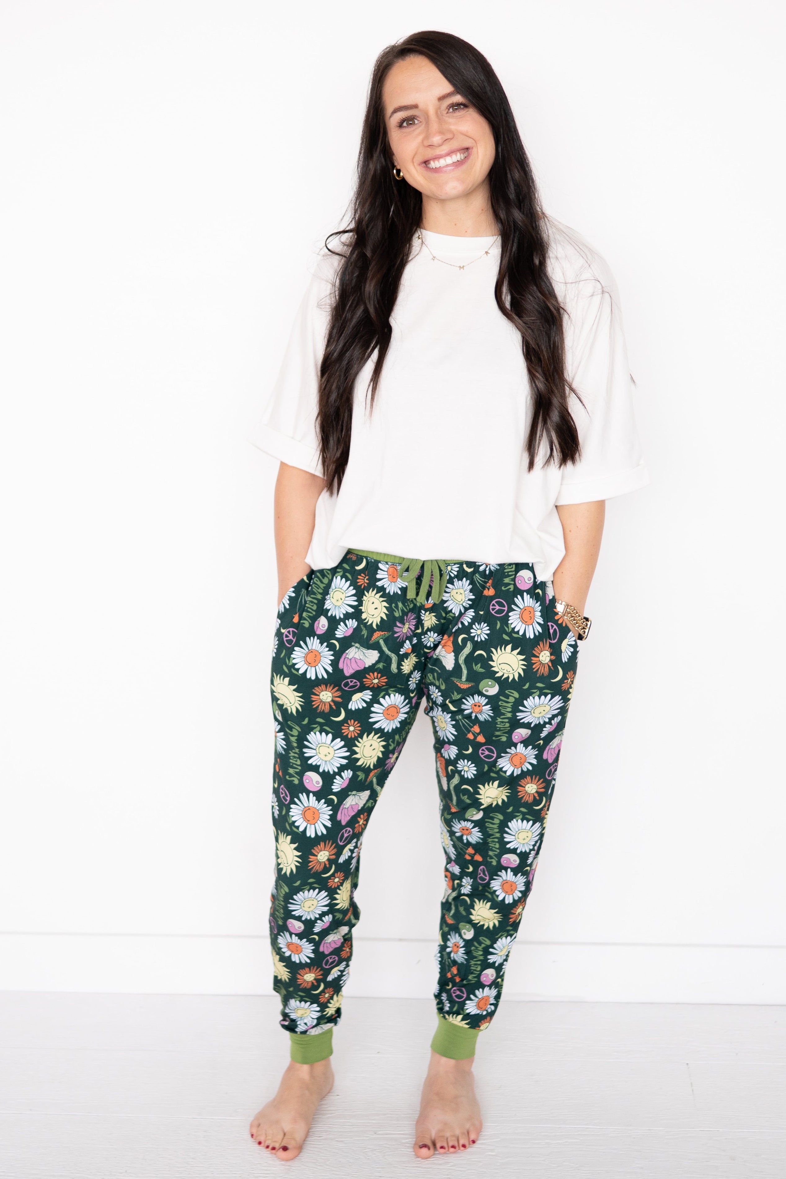 Women's dark green joggers with a colorful floral and smiley face print.