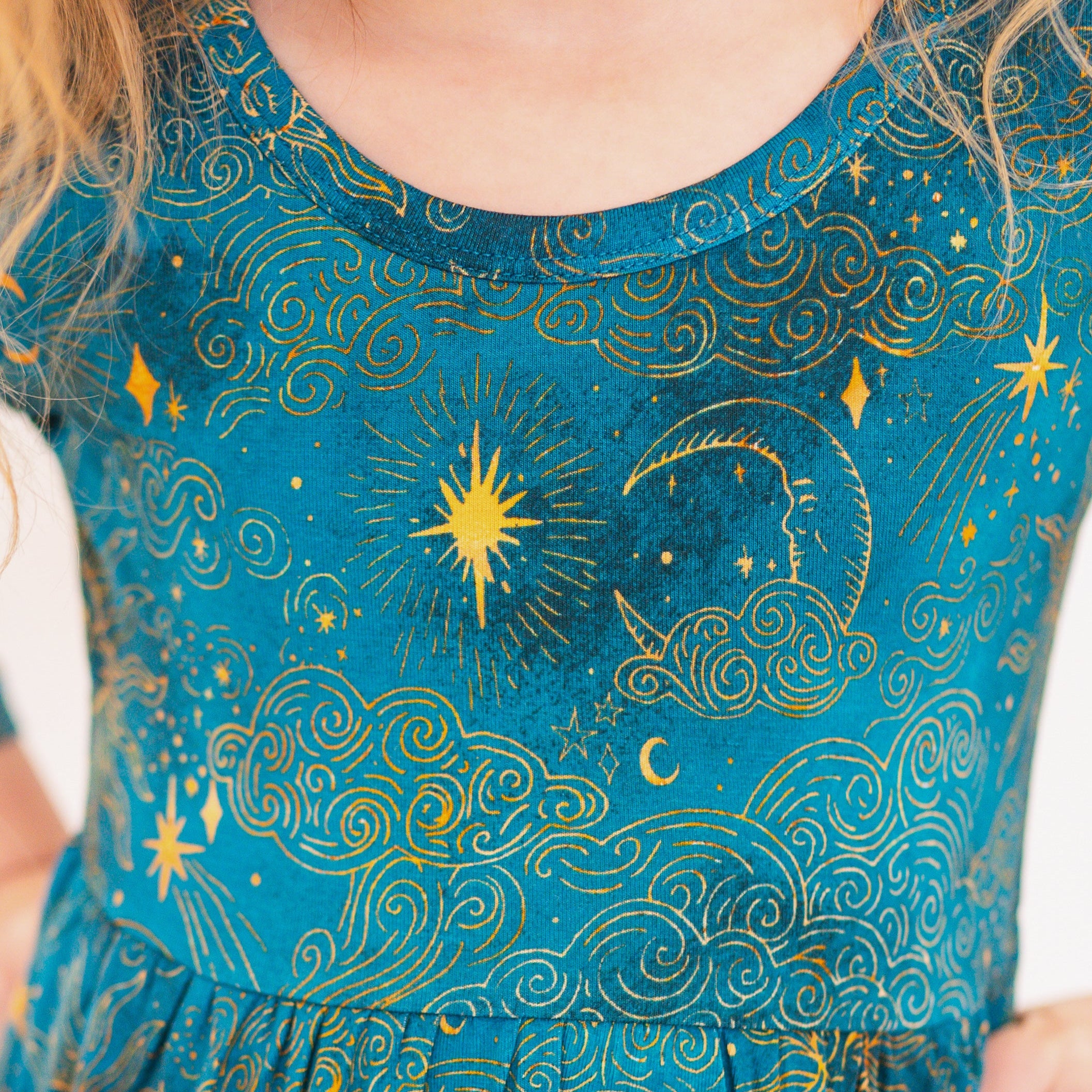 3/4 sleeve dress in teal with a celestial print of moons, stars, and clouds.