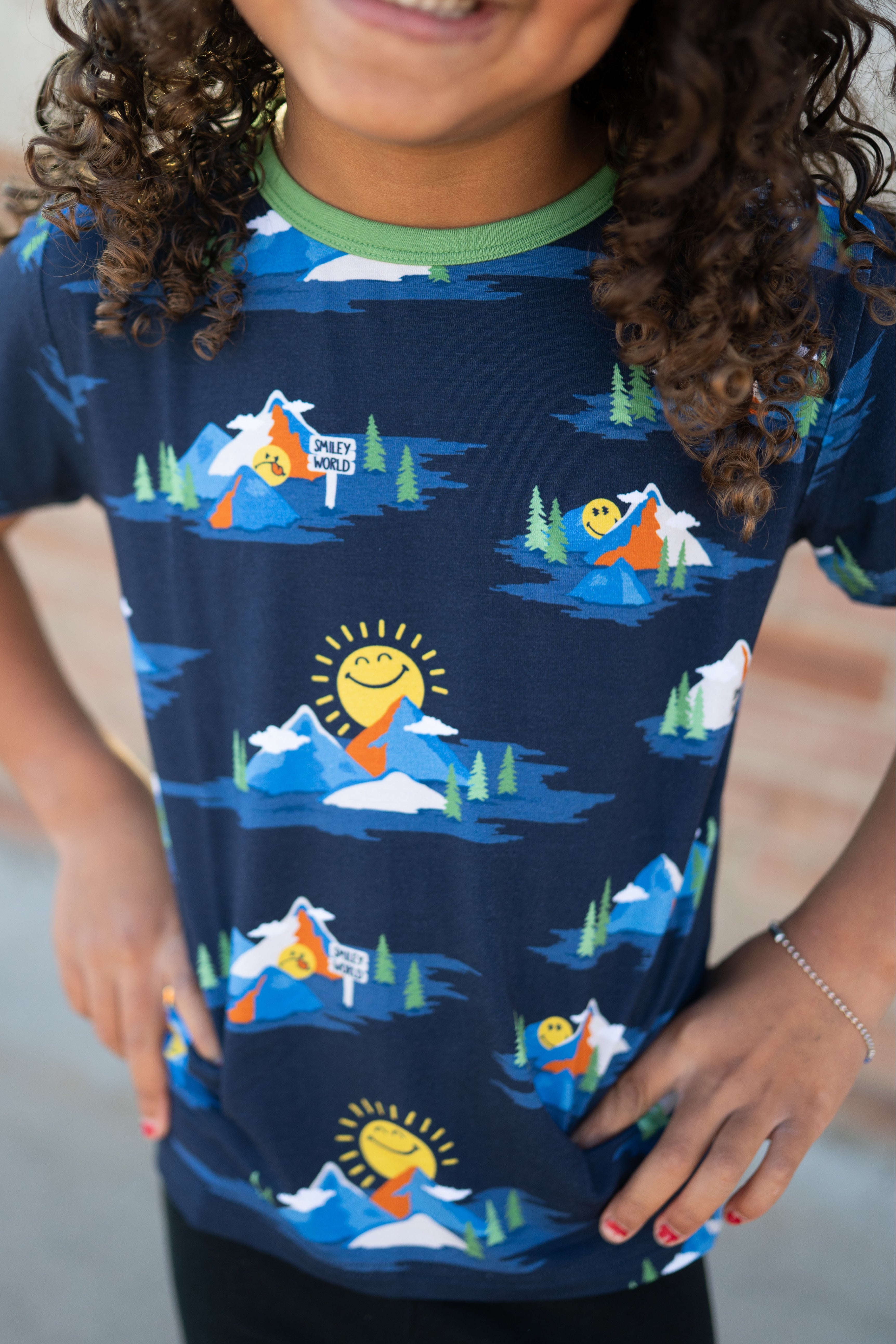 T-shirt with a navy blue all-over print of mountains and smiley faces.