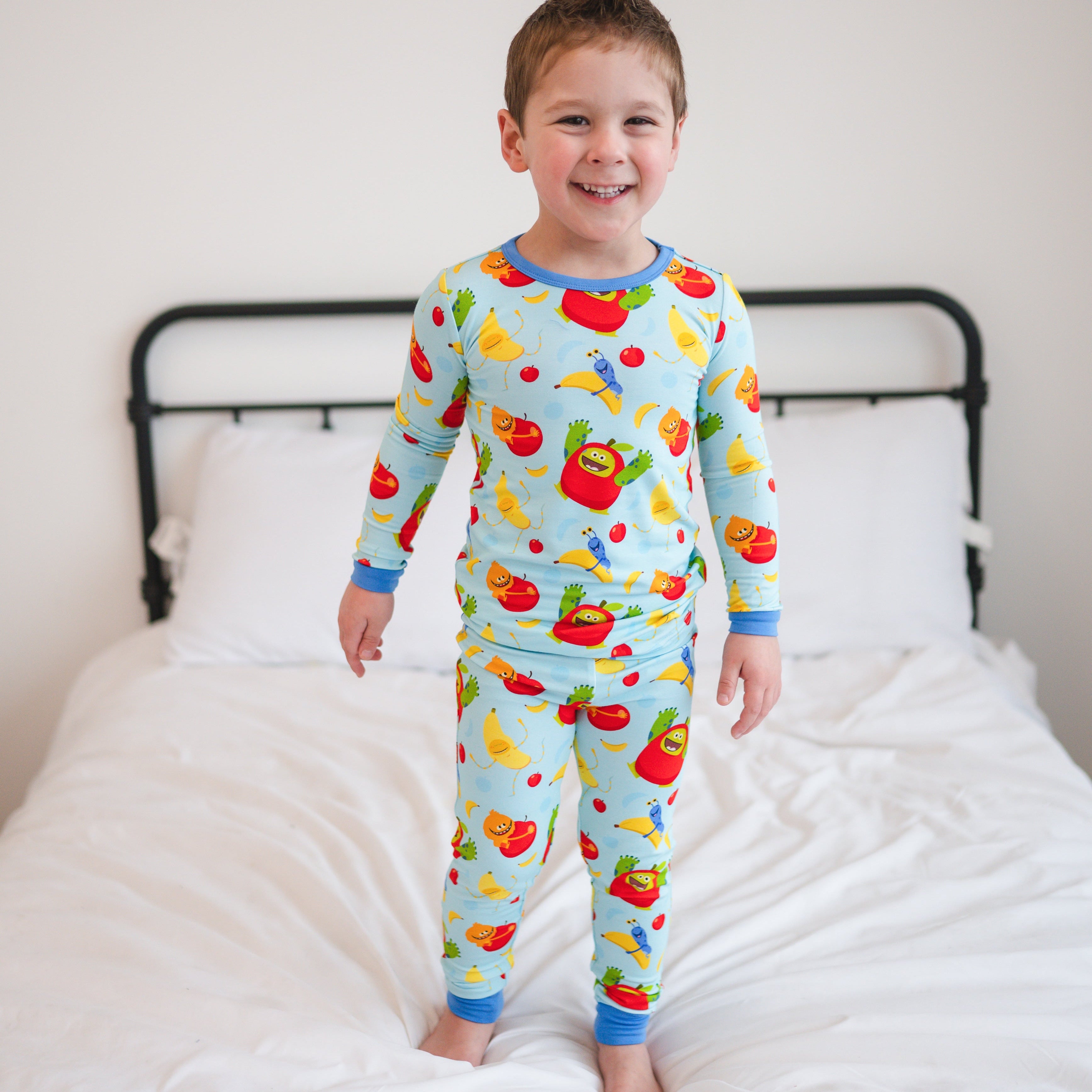 Light blue long sleeve pajamas for kids with an apples and bananas print.