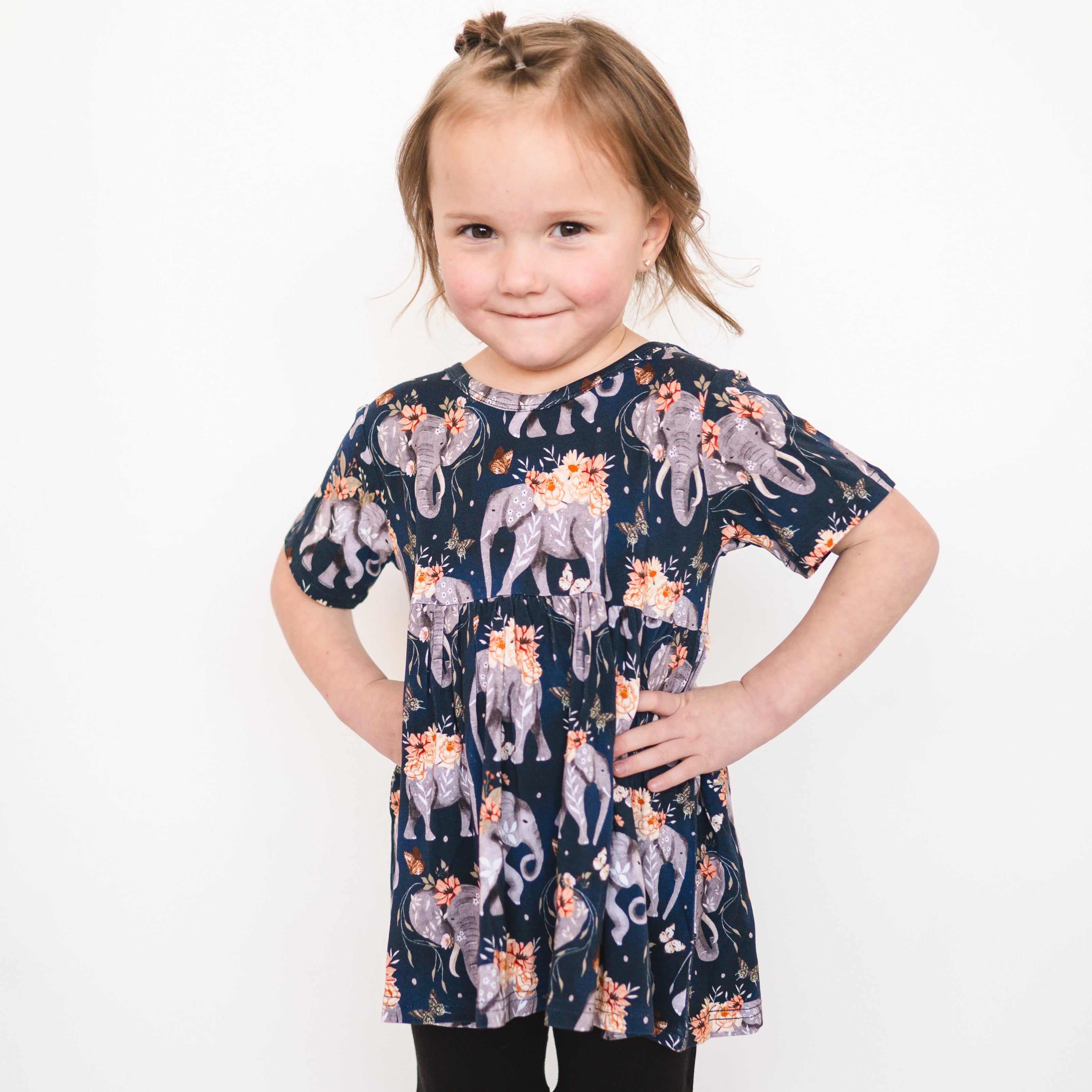 Short sleeve peplum top with an elephant and floral print.