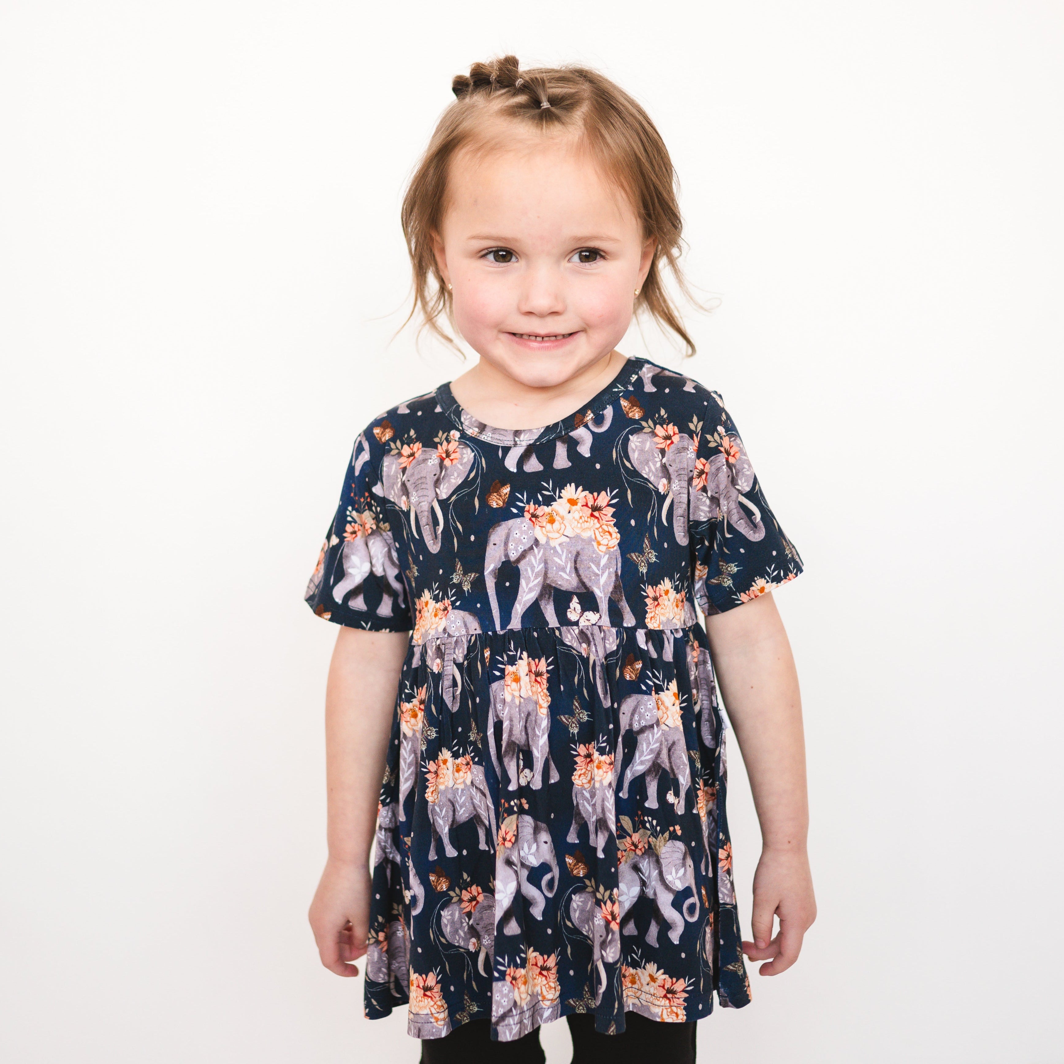 Short sleeve peplum top with an elephant and floral print.