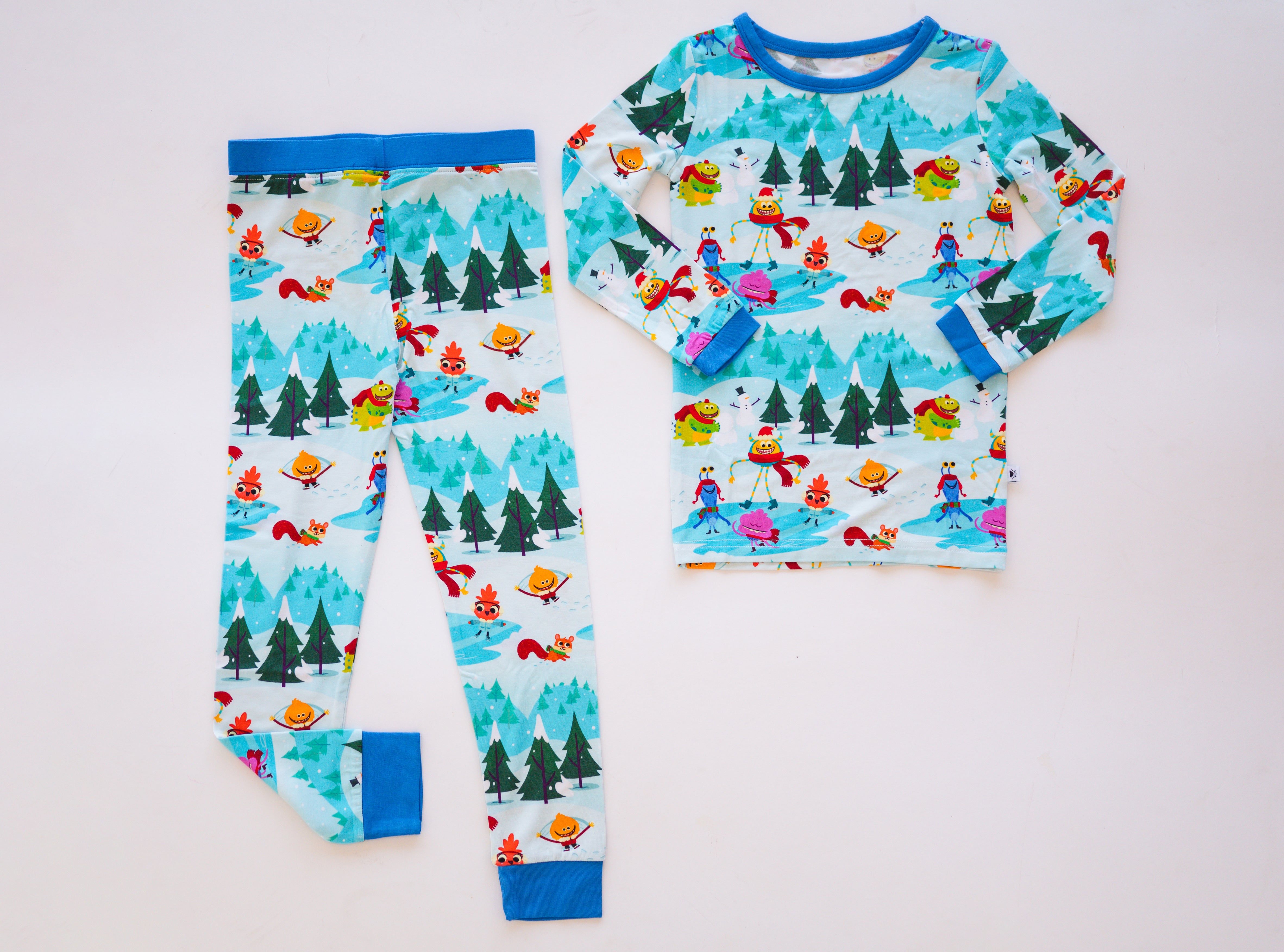 A long-sleeved pajama set and pants with a winter scene and cartoon characters.