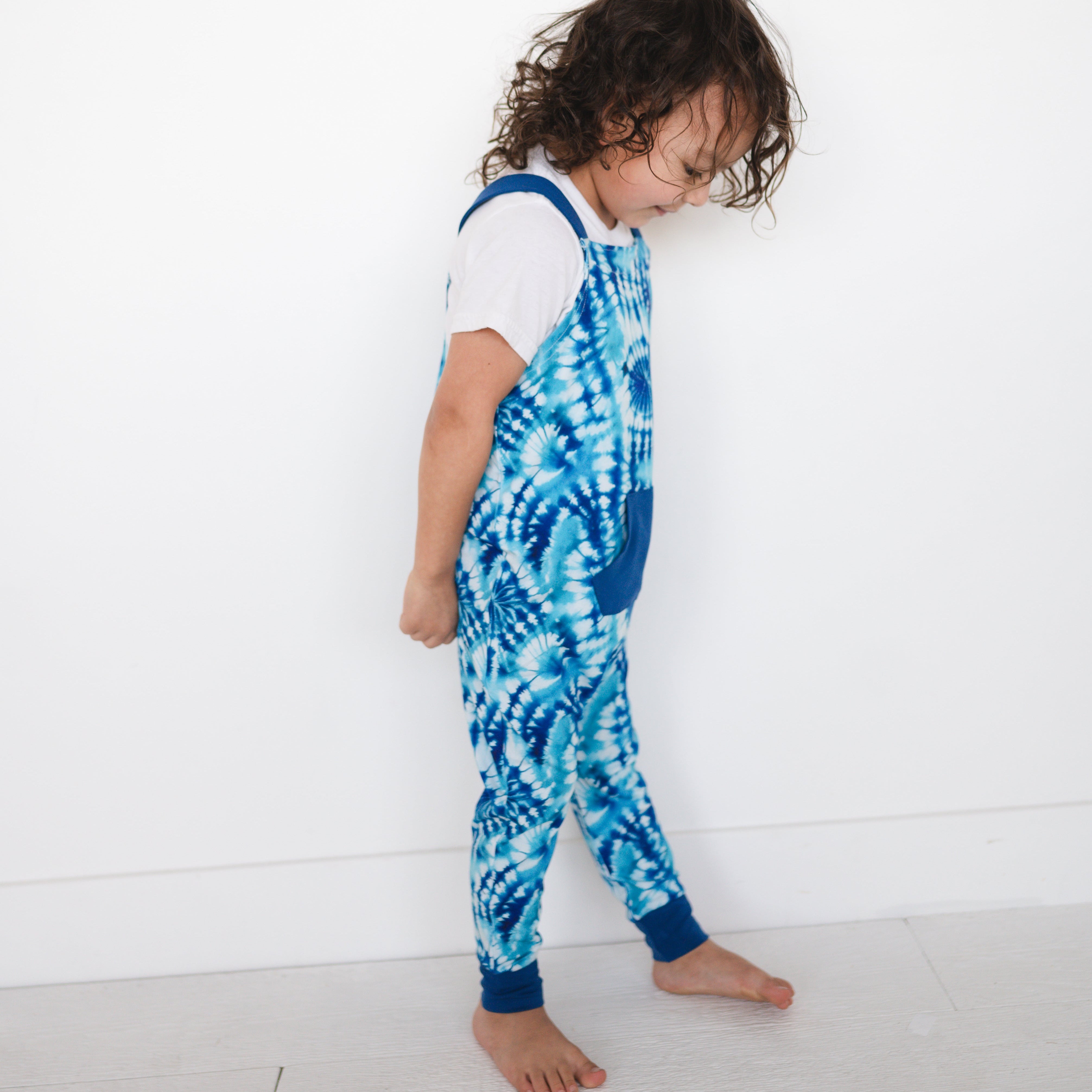 Toddler overalls with a blue and white tie-dye print.