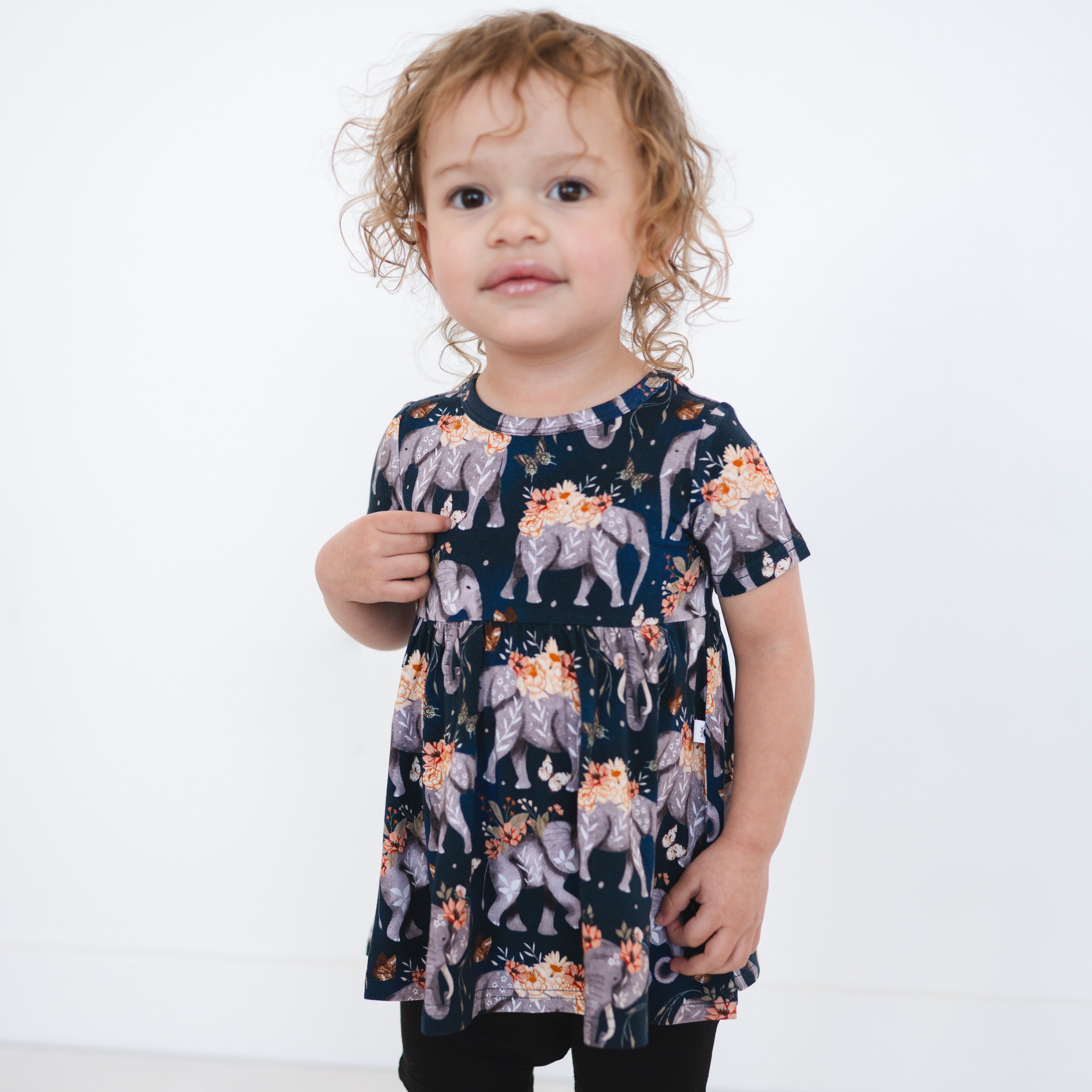 Short sleeve peplum top with an elephant and floral print.