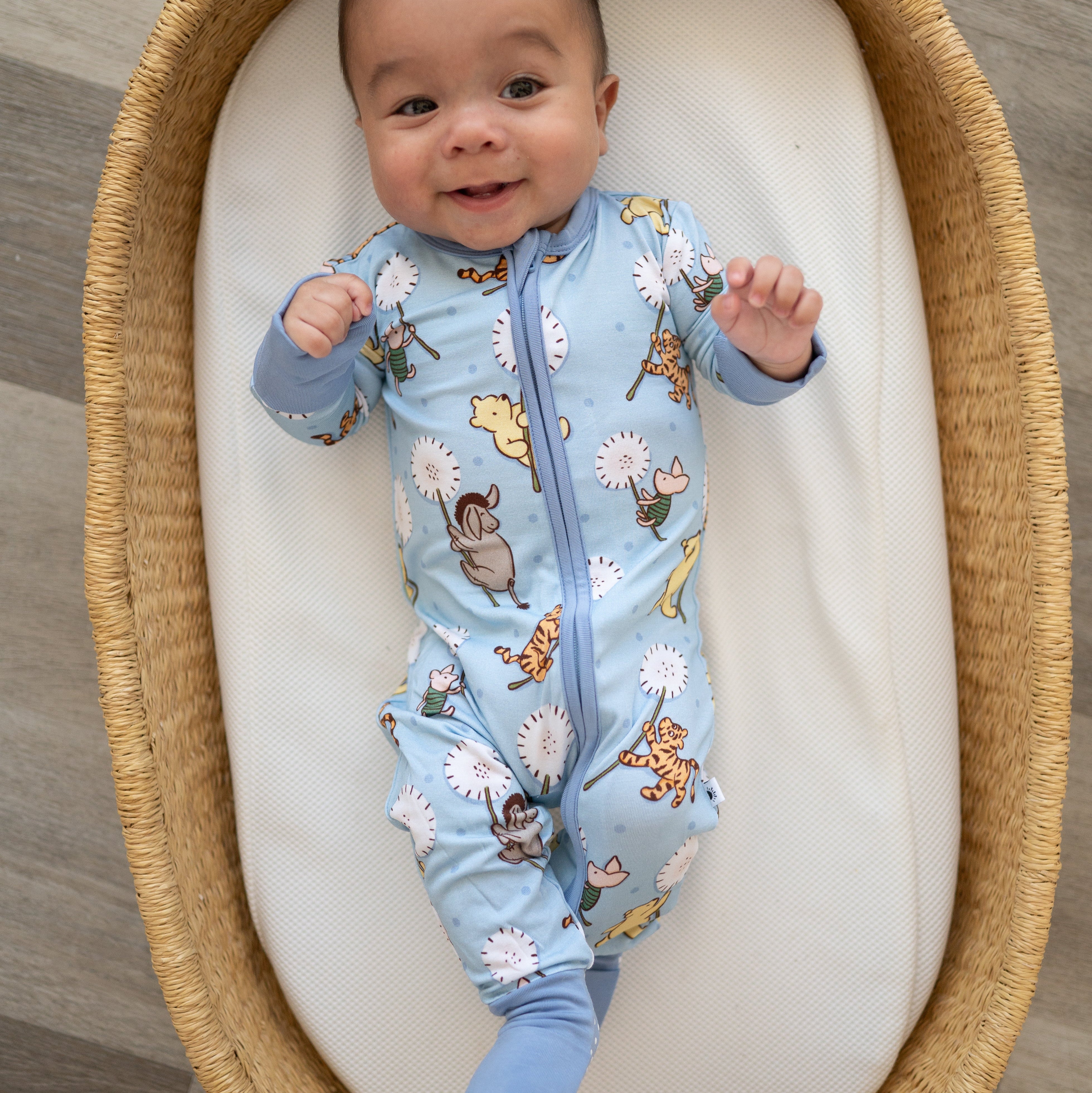 Baby in a light blue pajama set with a Winnie the Pooh print.