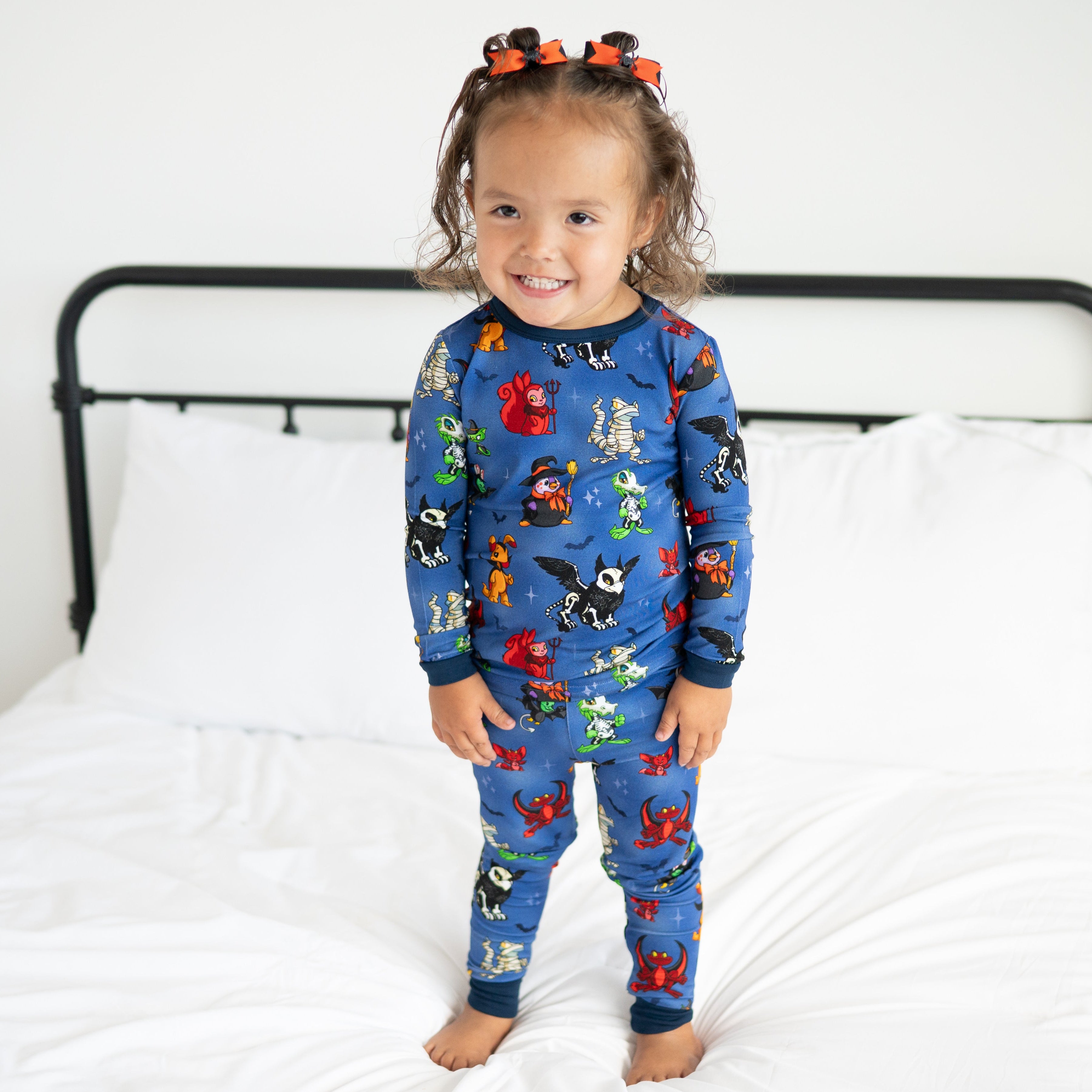 A young girl wears blue Halloween-themed Neopets pajamas.