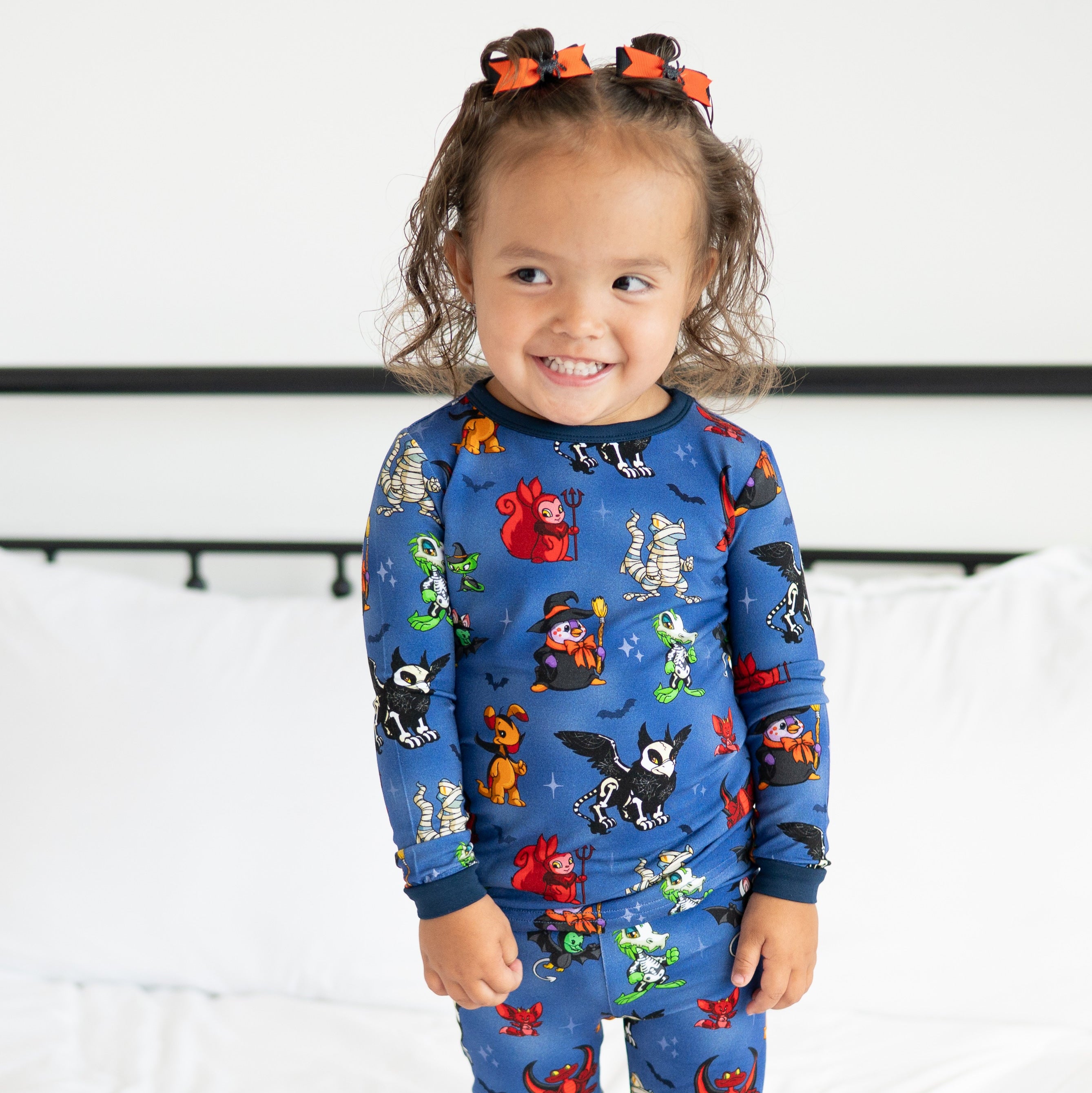 A young girl wears blue Halloween-themed Neopets pajamas.