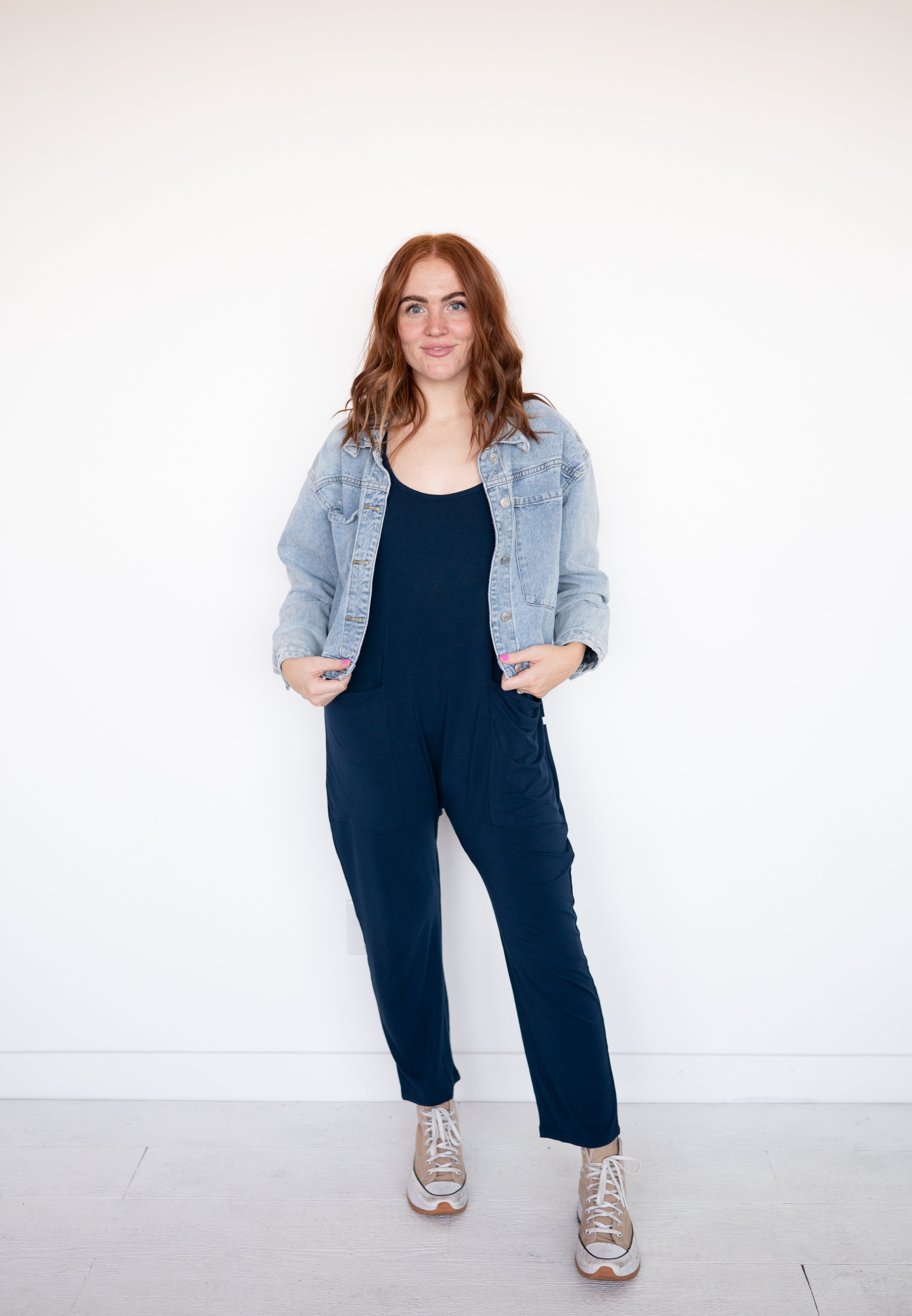 Navy luxe bamboo overalls with a denim jacket and sneakers.
