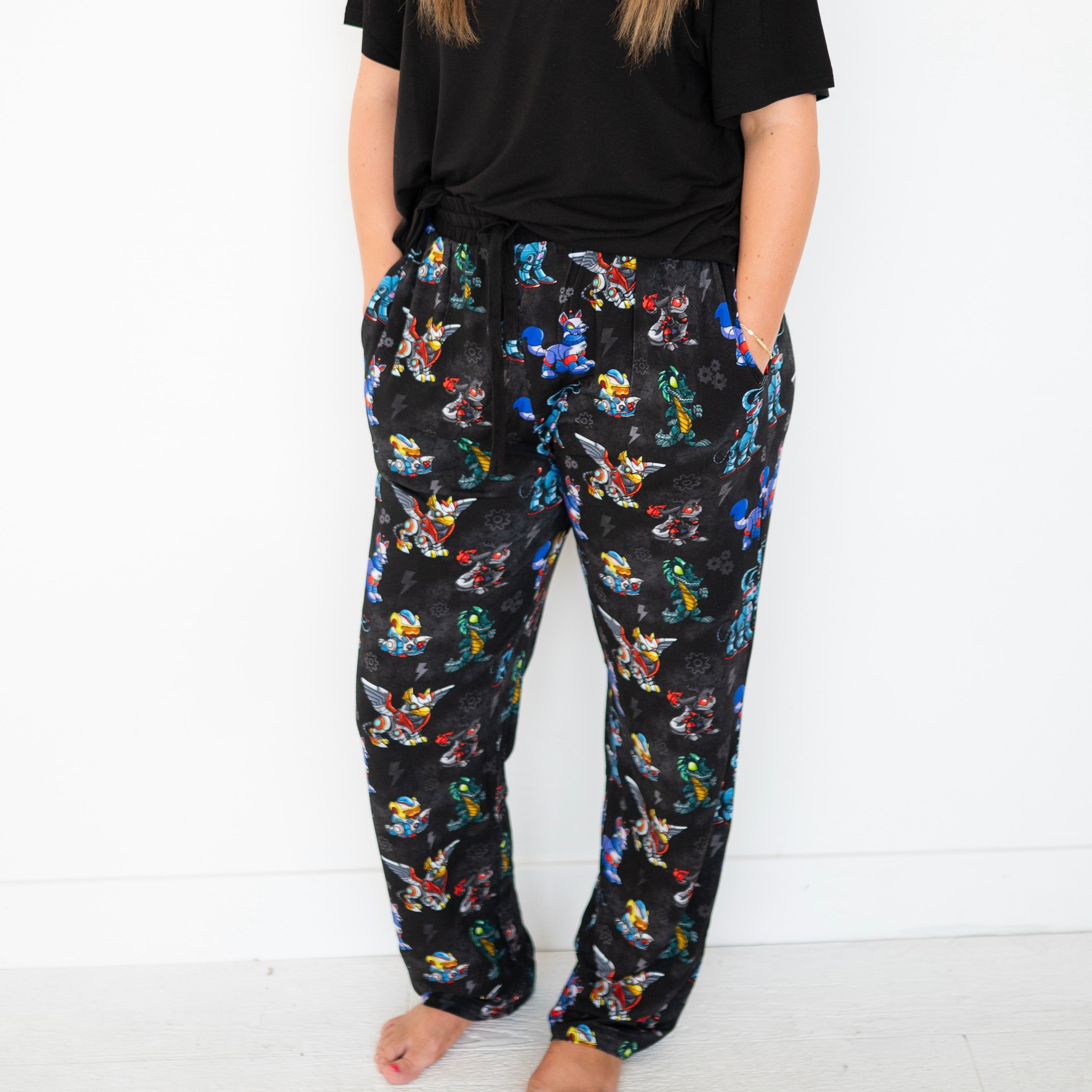 Unisex adult sleep pants with a black background and a colorful Neopets robot pattern.