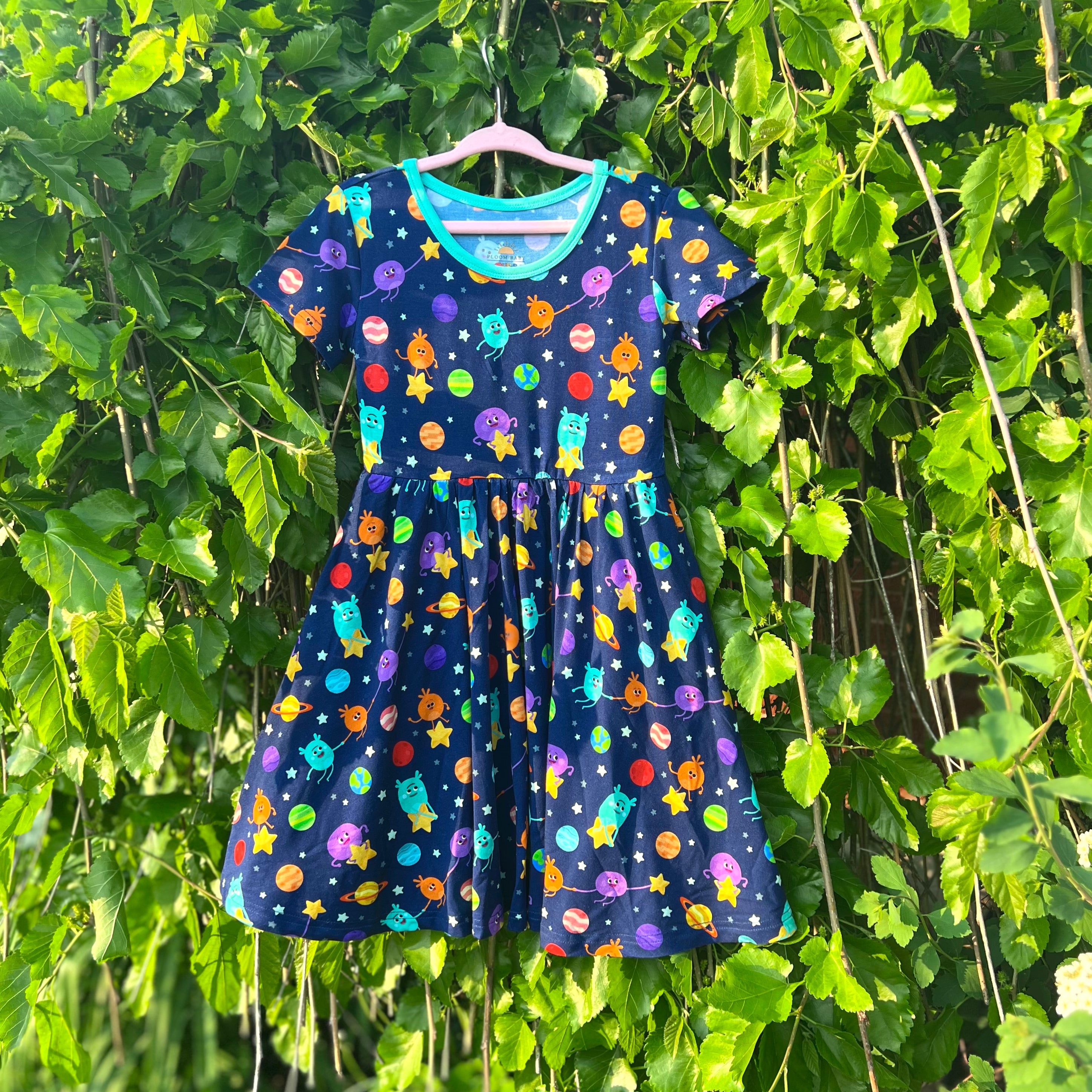 A navy blue dress with a space-themed print of aliens and planets.