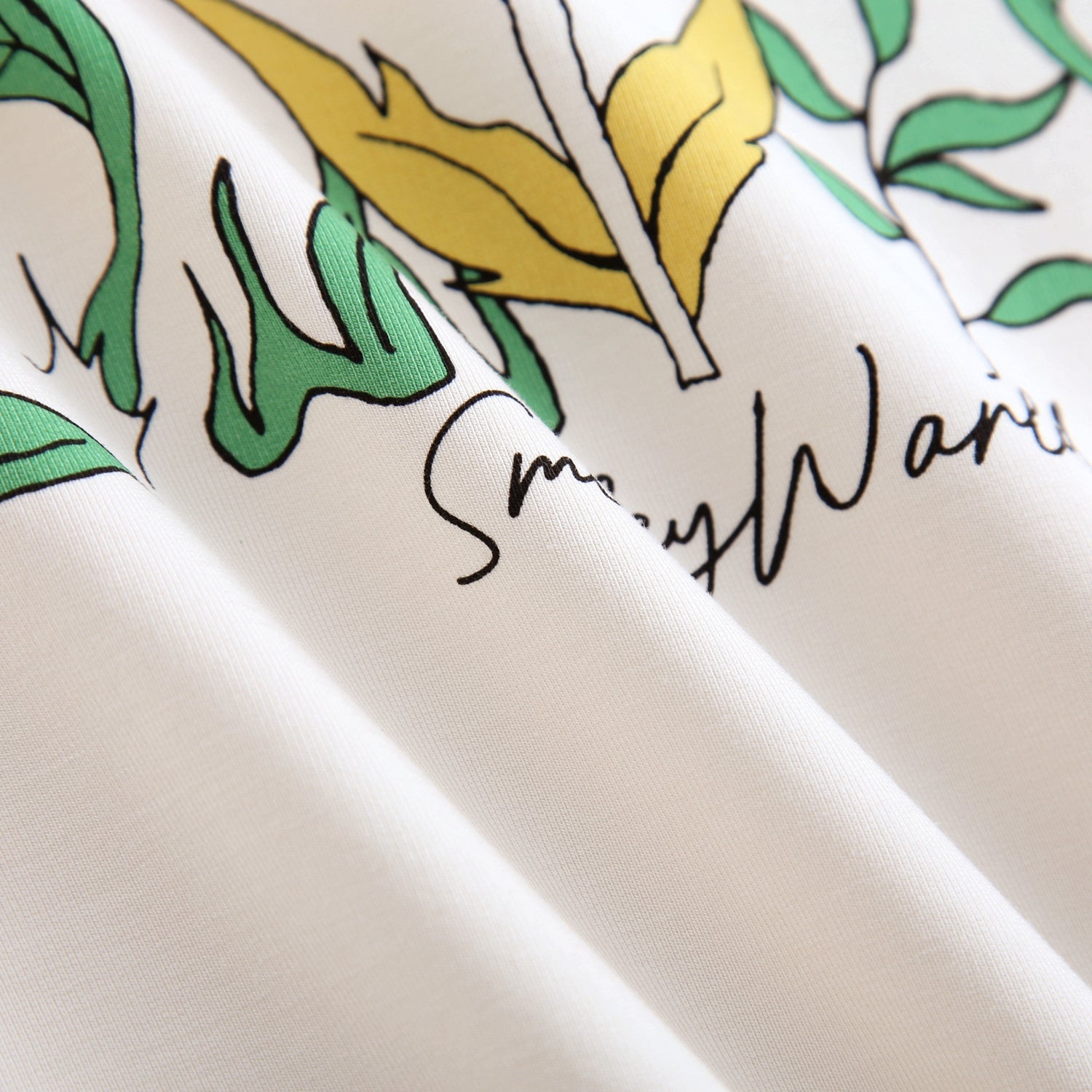 White crewneck sweatshirt with green and yellow floral print and "SmileyWorld" text.