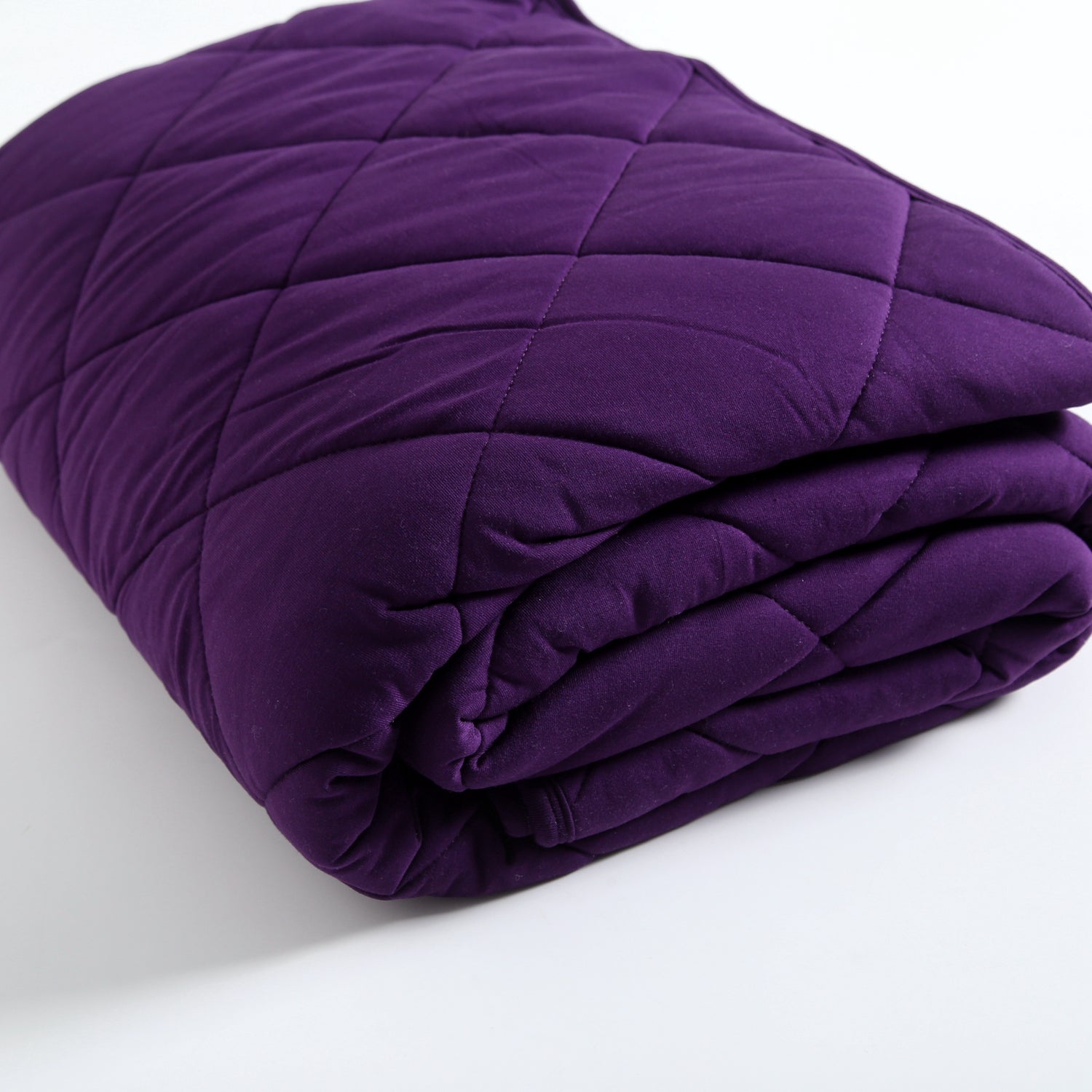 A folded, quilted blackberry purple bamboo blanket.