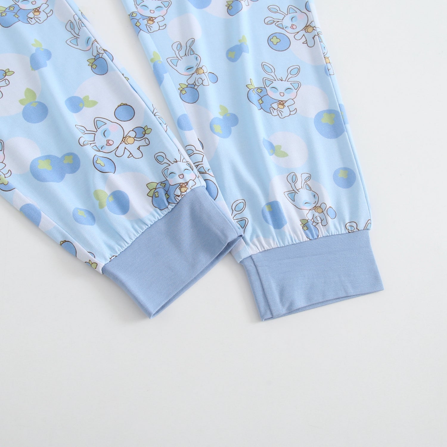 Light blue joggers with a repeating pattern of cute blue bunnies and blueberries.