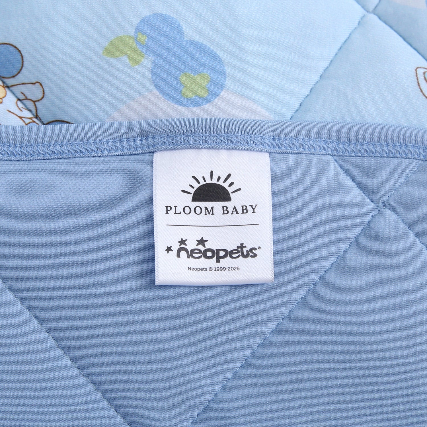 A blue quilted blanket with a "Ploom Baby" and "Neopets" tag.