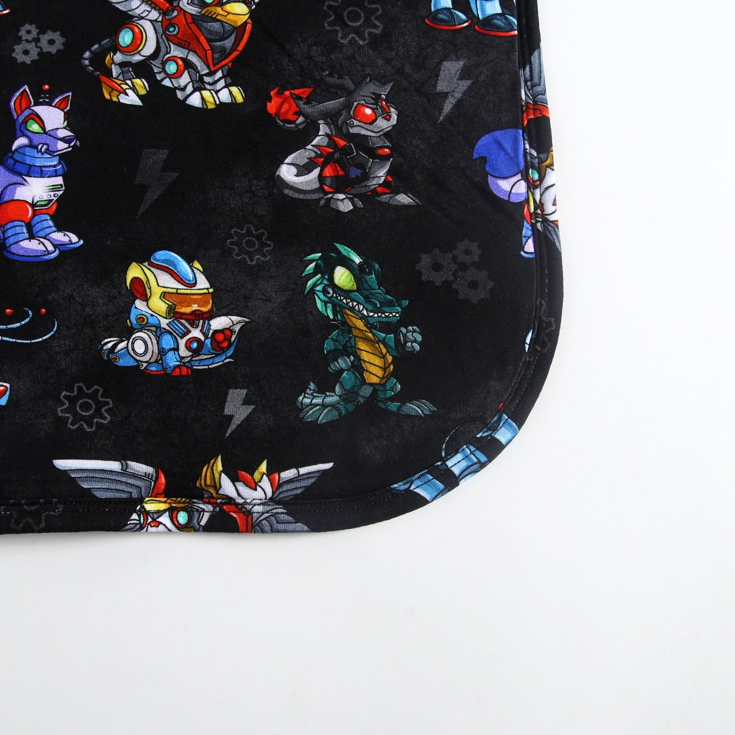 A black plush blanket with a repeating pattern of colorful robot characters.