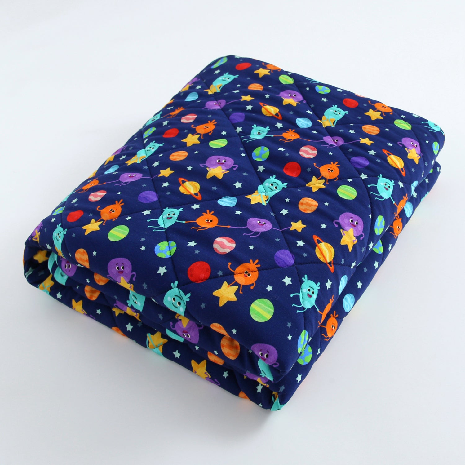A quilted blanket with a dark blue space-themed print featuring cartoon aliens and planets.