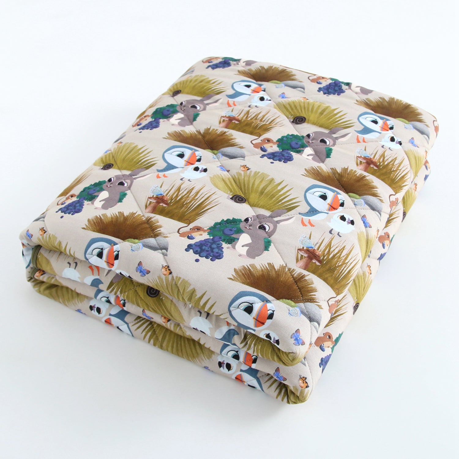 A quilted bamboo blanket with a Puffin Rock™ pattern featuring puffins and rabbits.
