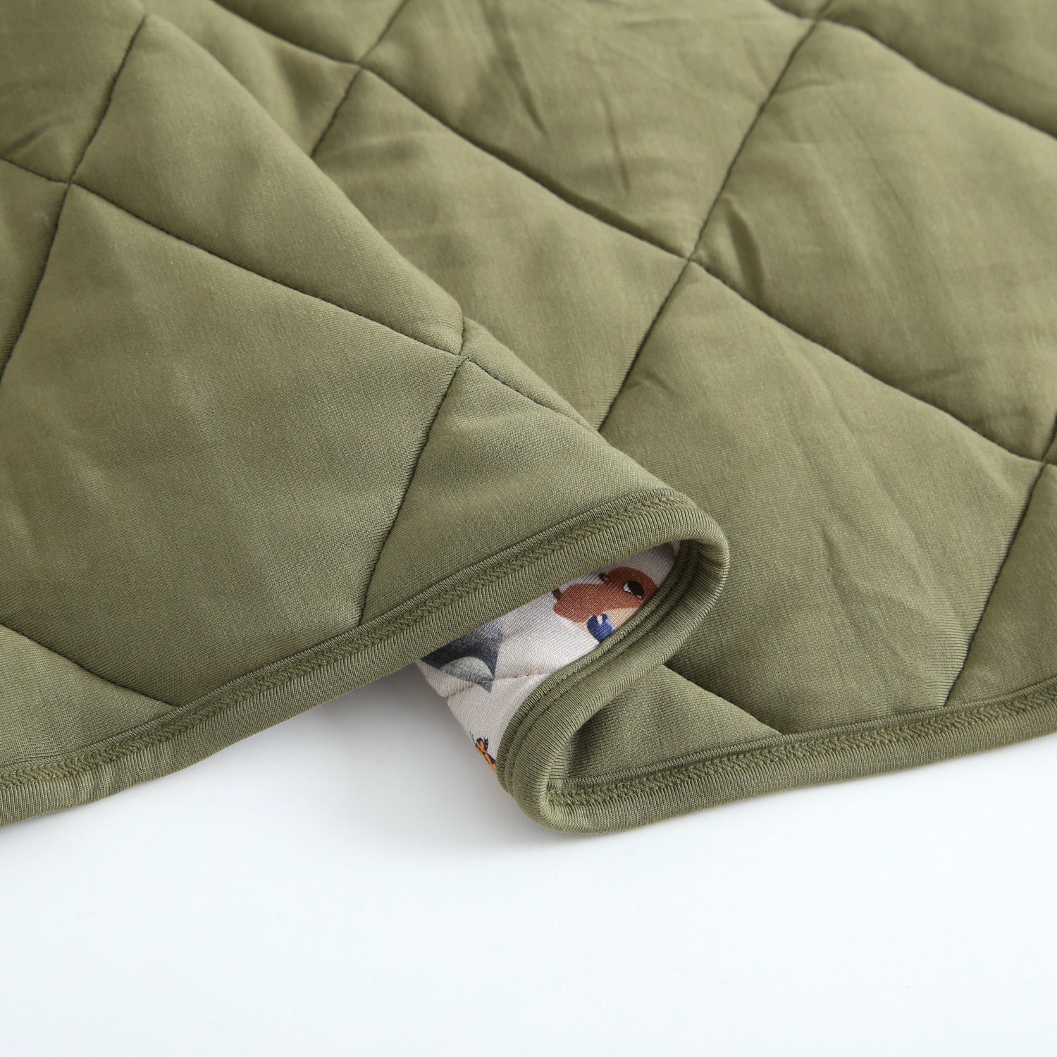 Quilted green bamboo blanket with a printed lining.