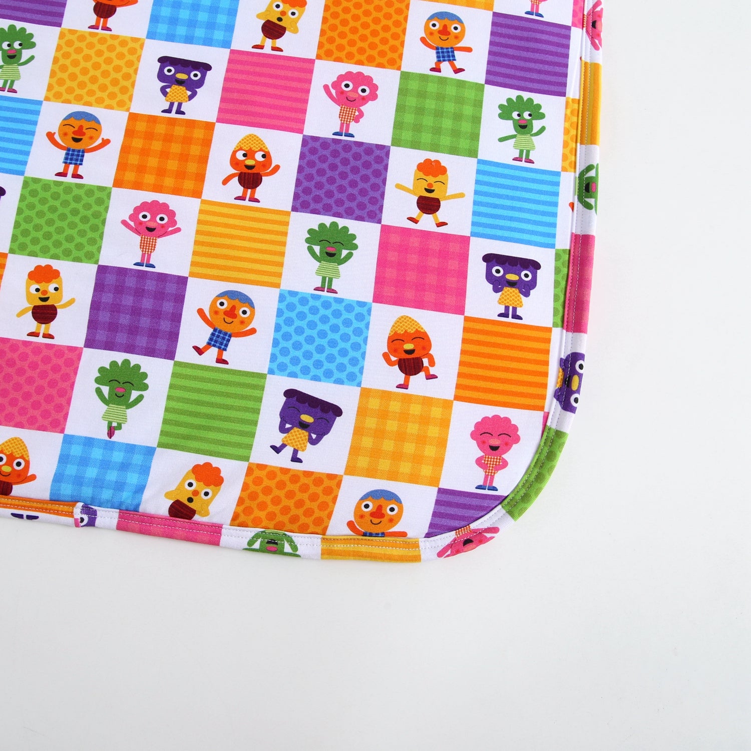A colorful blanket with cartoon characters on a checkered pattern.