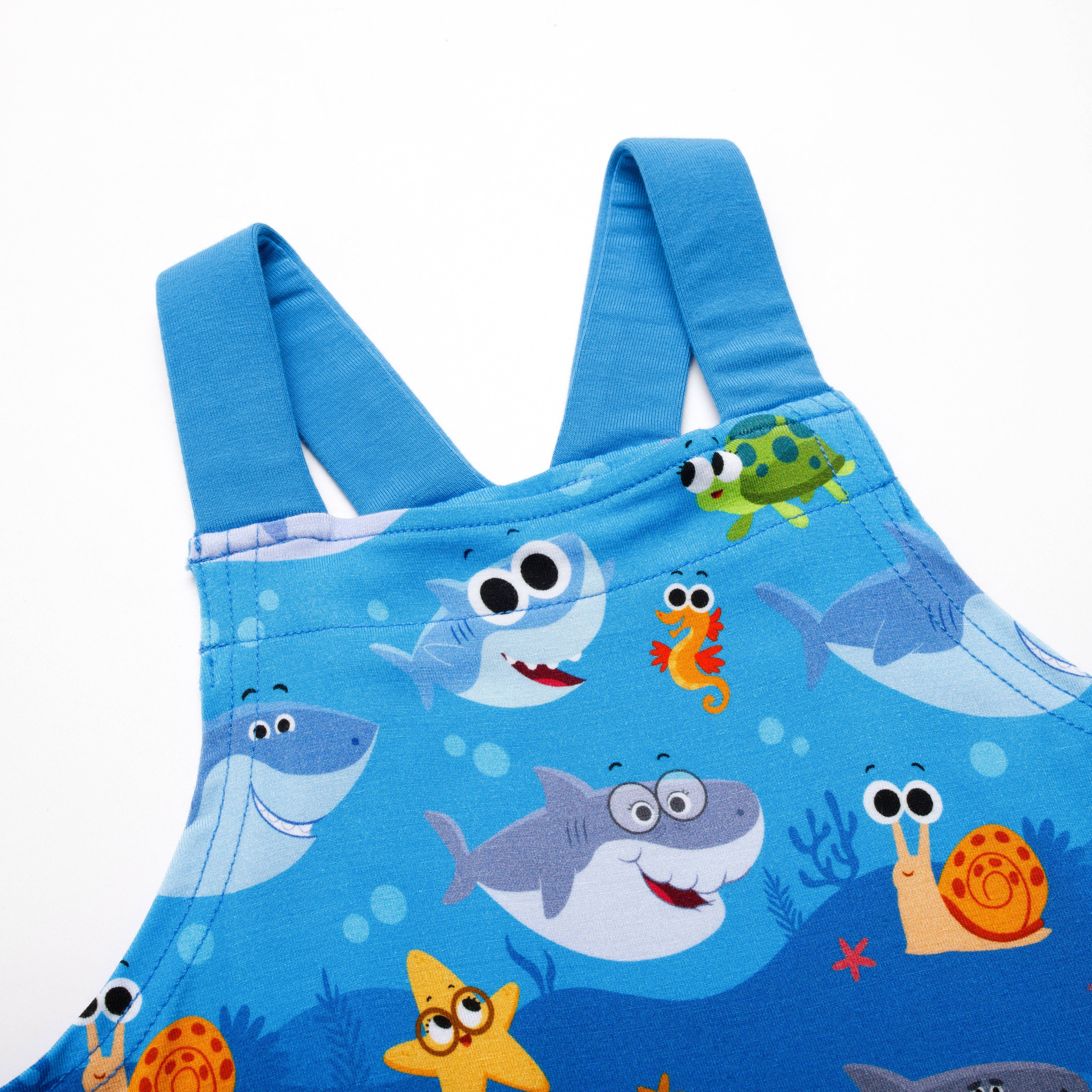 Blue overalls with a playful baby shark and ocean creature print.