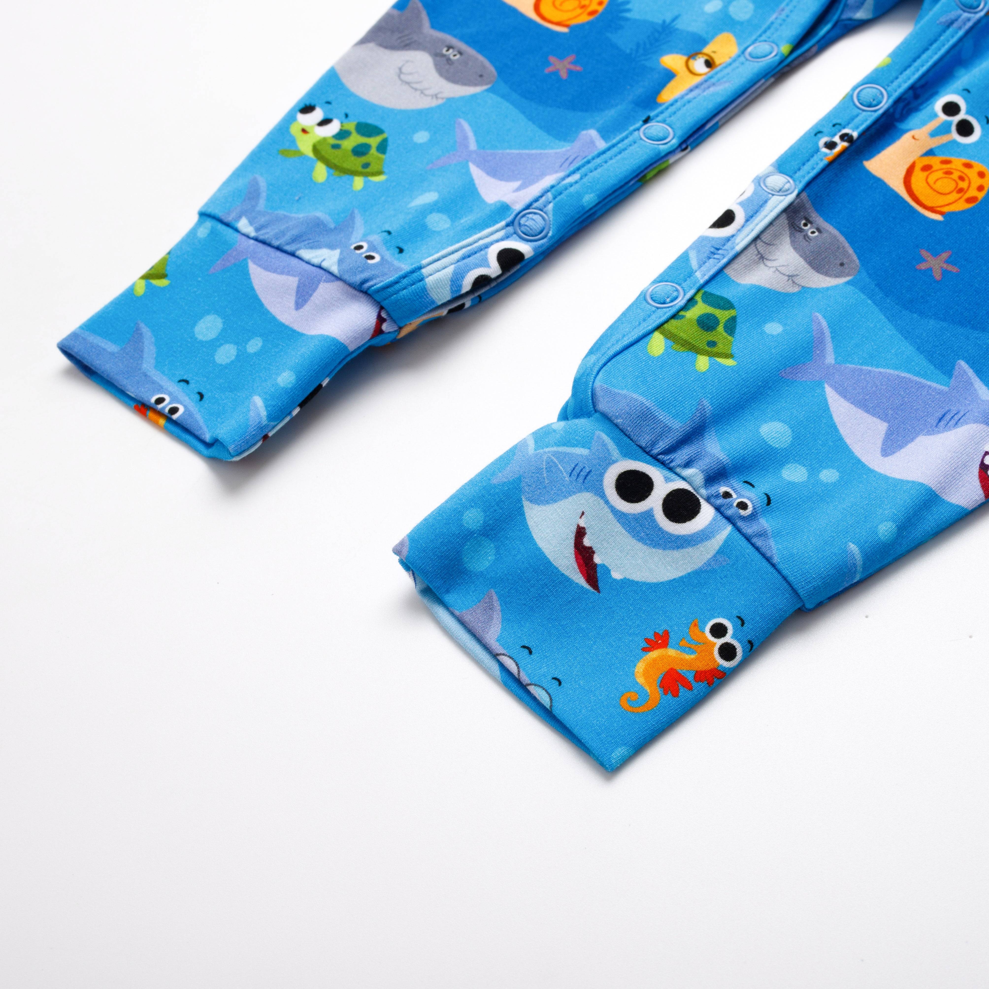 Blue baby overalls with a playful shark and sea creature print.