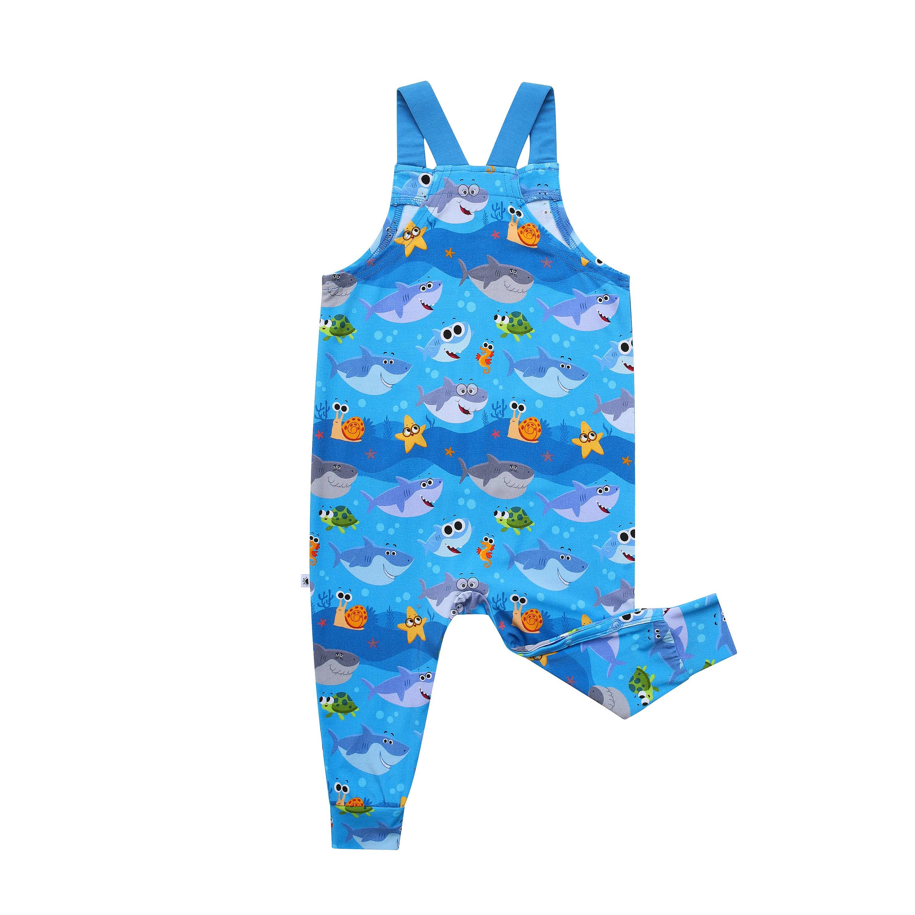 Blue overalls with a repeating pattern of cartoon sharks, turtles, and sea creatures.