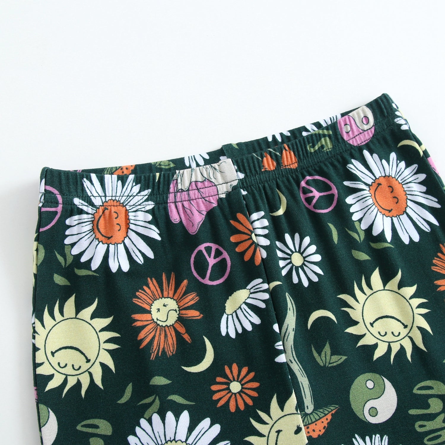 Green leggings with a groovy floral and smiley sun print.
