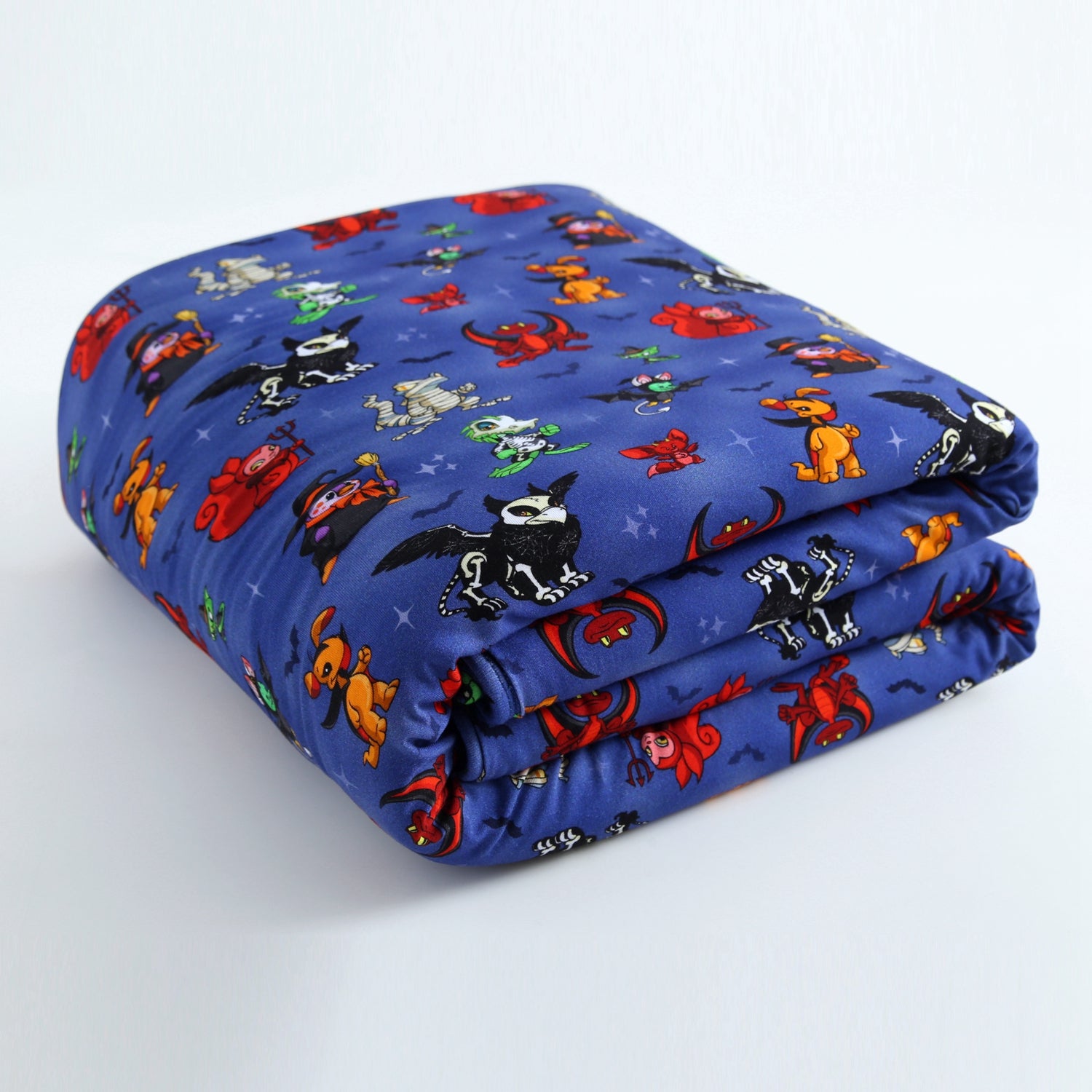 A folded blue blanket with a Halloween-themed Neopets print.