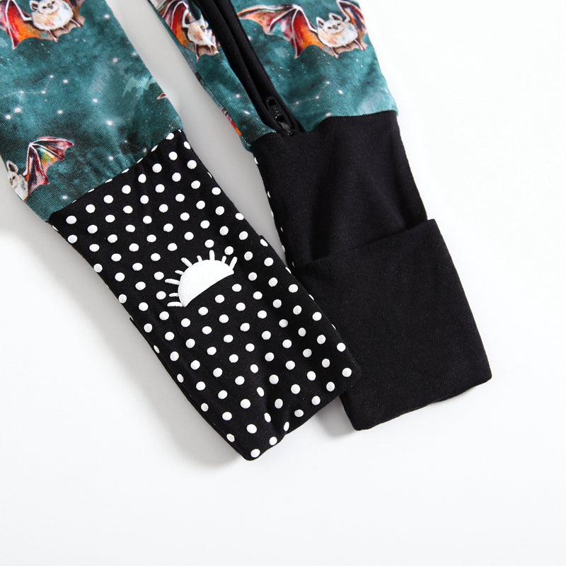 Close-up of bamboo pajamas with a bat print and polka dot cuffs.
