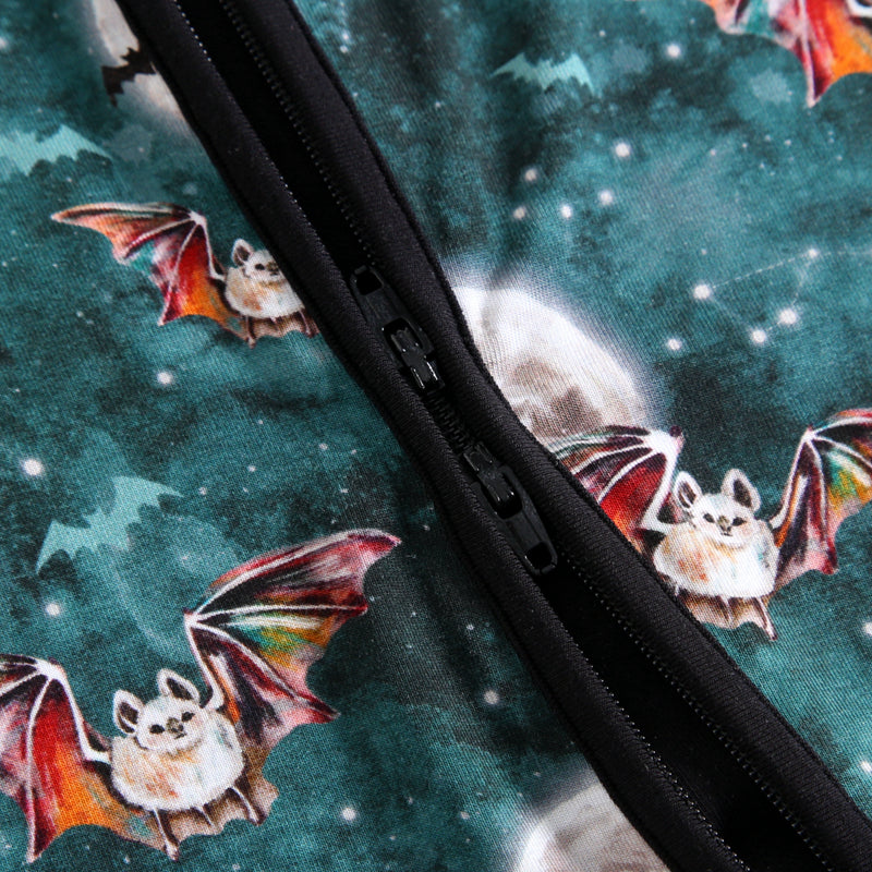 Close-up of a teal pajama with a bat print and a black zipper.