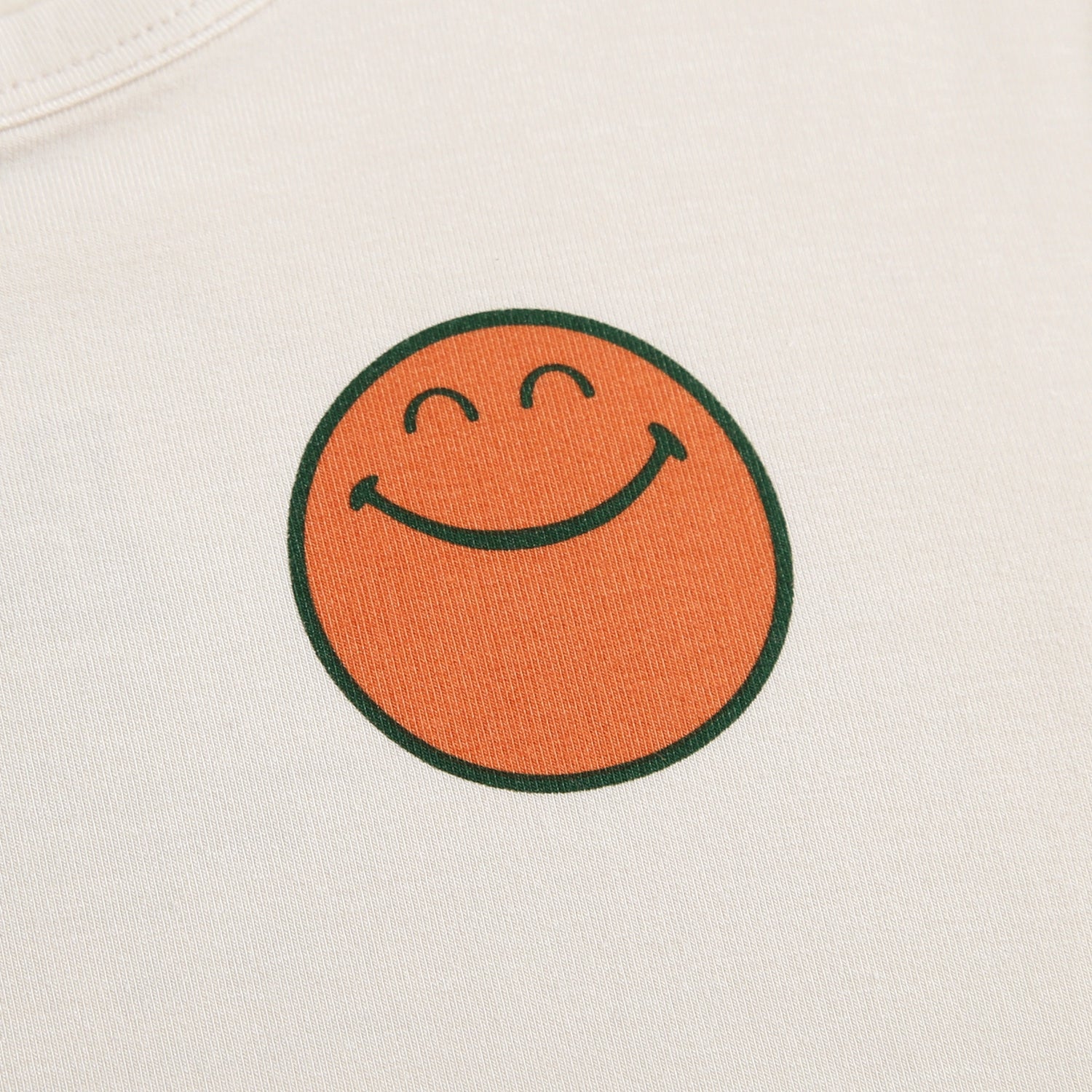T-shirt with an orange smiley face graphic.